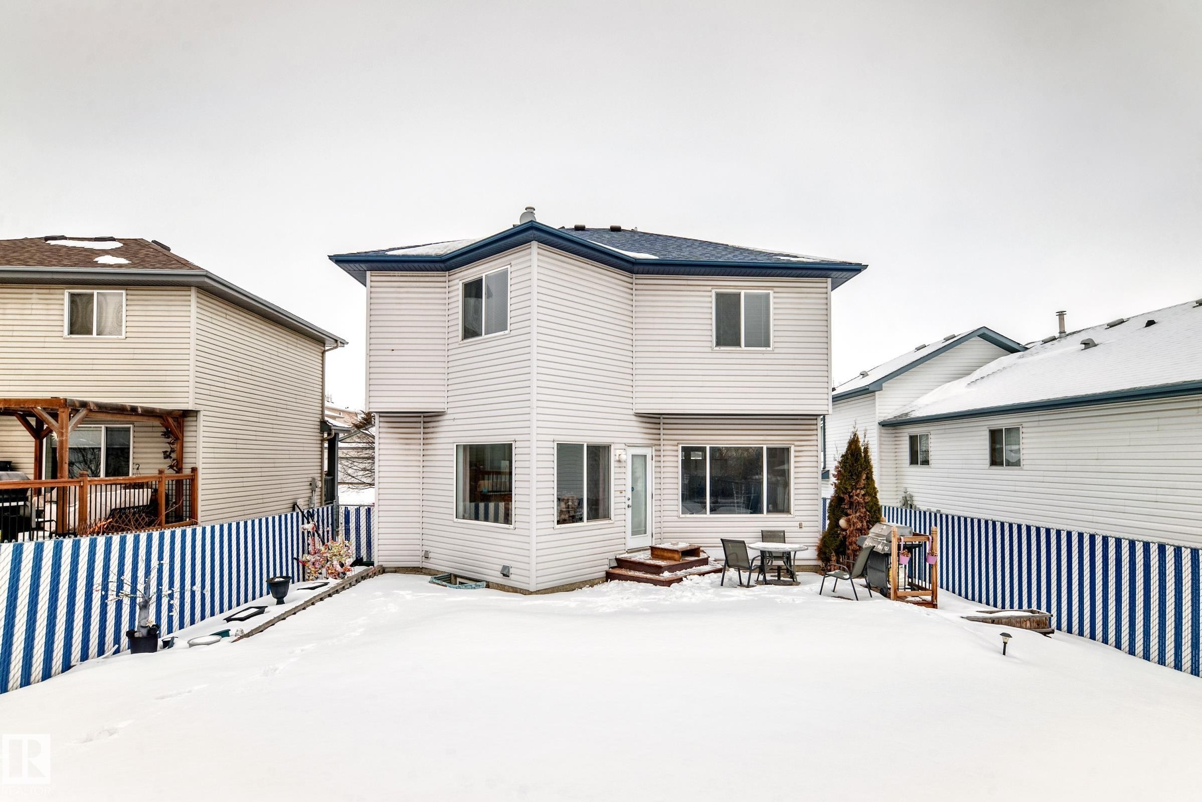 Snow covered property featuring a wooden deck, a patio area, and entry steps - 4619 151 Avenue, Edmonton, AB - Outdoor With Exterior