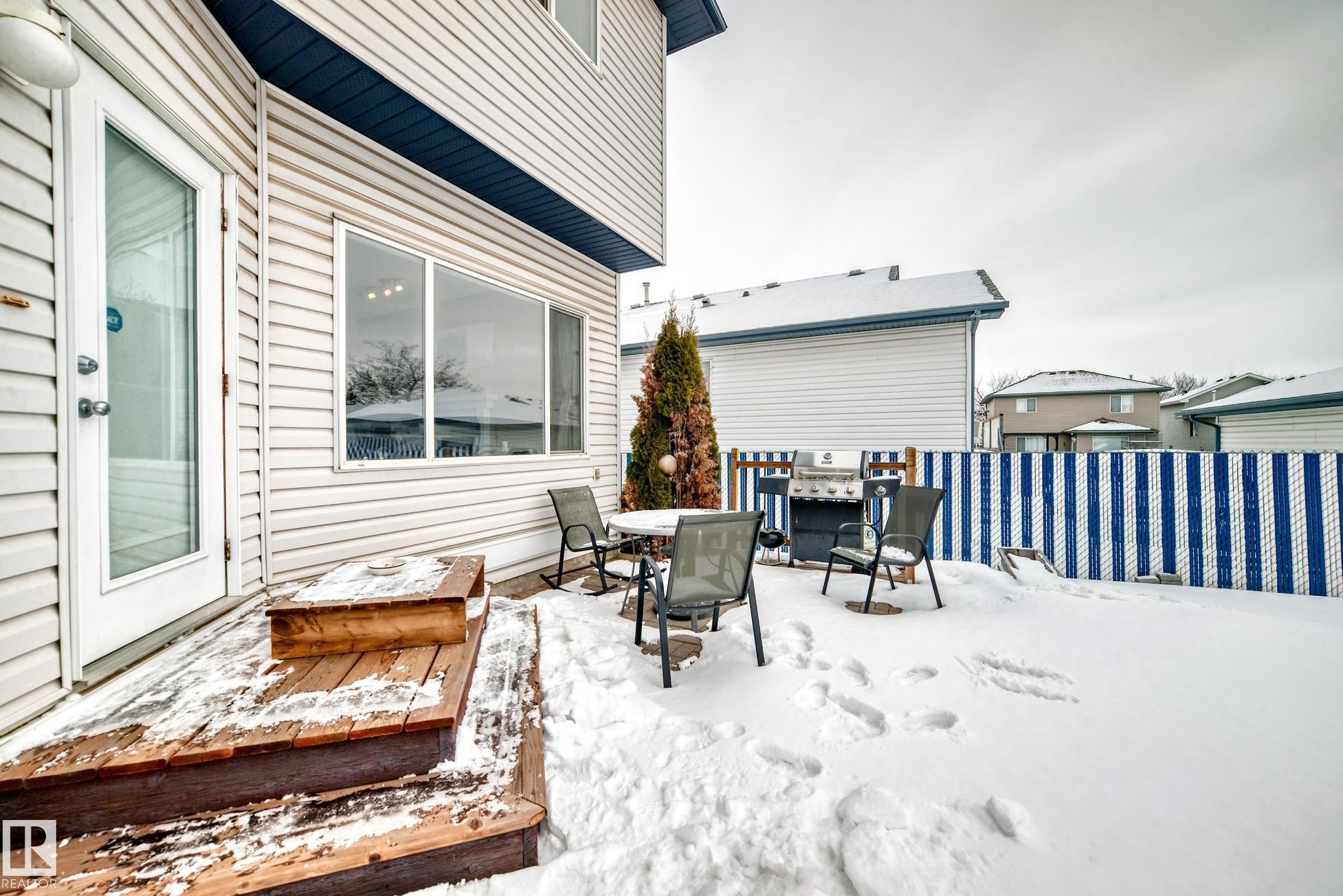 Snow covered patio featuring outdoor dining space and a deck - 4619 151 Avenue, Edmonton, AB - Outdoor With Deck Patio Veranda With Exterior
