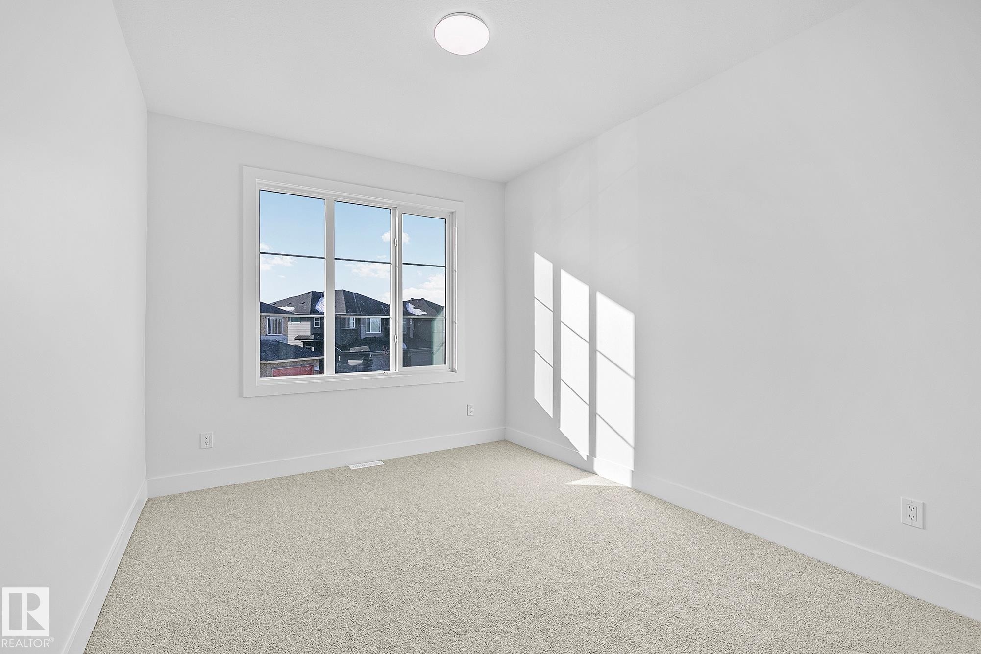 Spare room with baseboards and light carpet - 523 Ashgrove Circle, Leduc, AB - Indoor Photo Showing Other Room