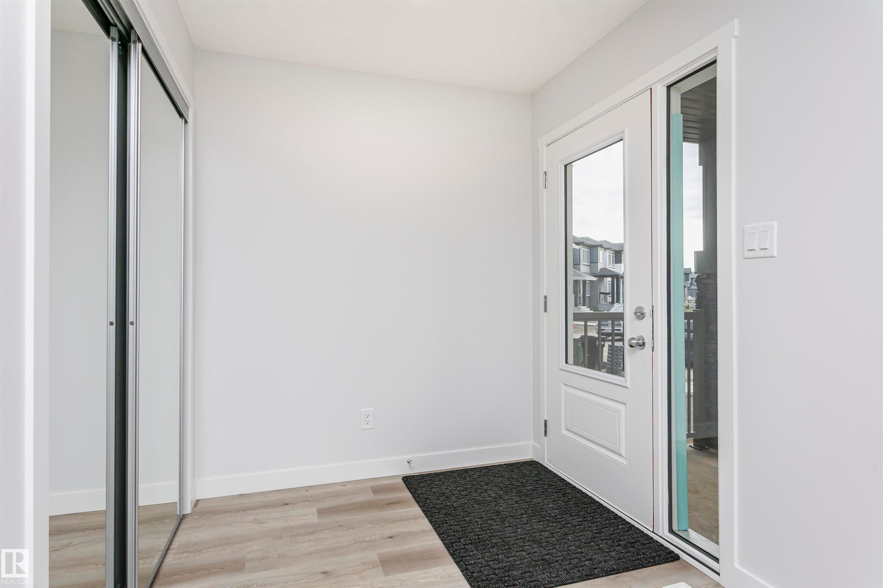 Doorway to outside with baseboards and wood finished floors - 9564 Carson Bend, Edmonton, AB - Indoor Photo Showing Other Room