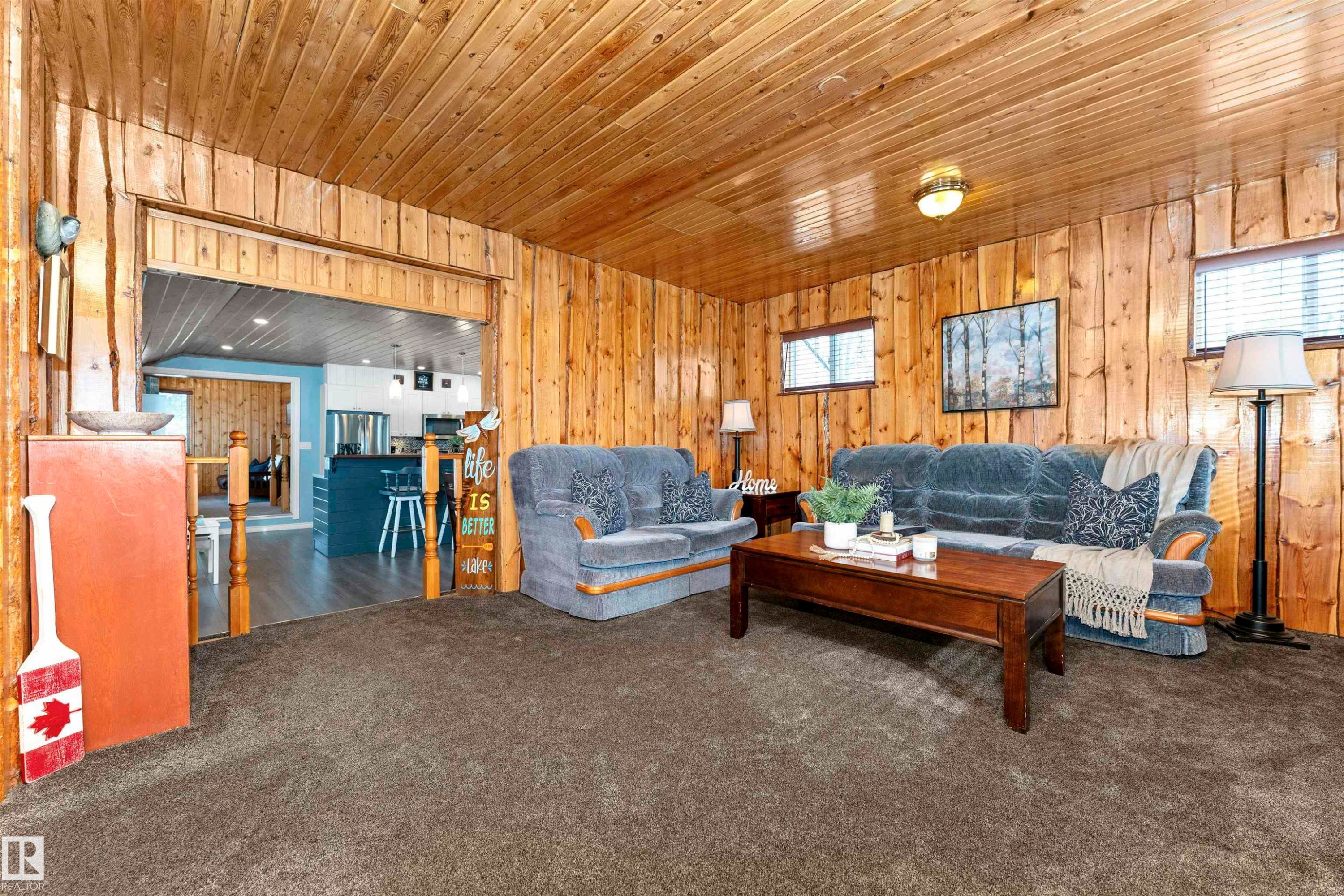 Carpeted living area with wooden ceiling and wood walls - 516 5 Street, Rural Lac Ste. Anne County, AB - Indoor Photo Showing Living Room
