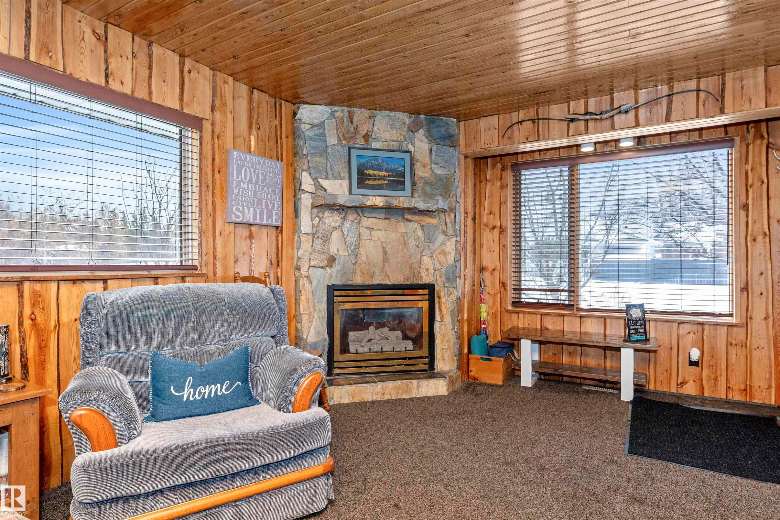 Sitting room featuring wood walls, carpet flooring, a fireplace, and wood ceiling - 516 5 Street, Rural Lac Ste. Anne County, AB - Indoor With Fireplace