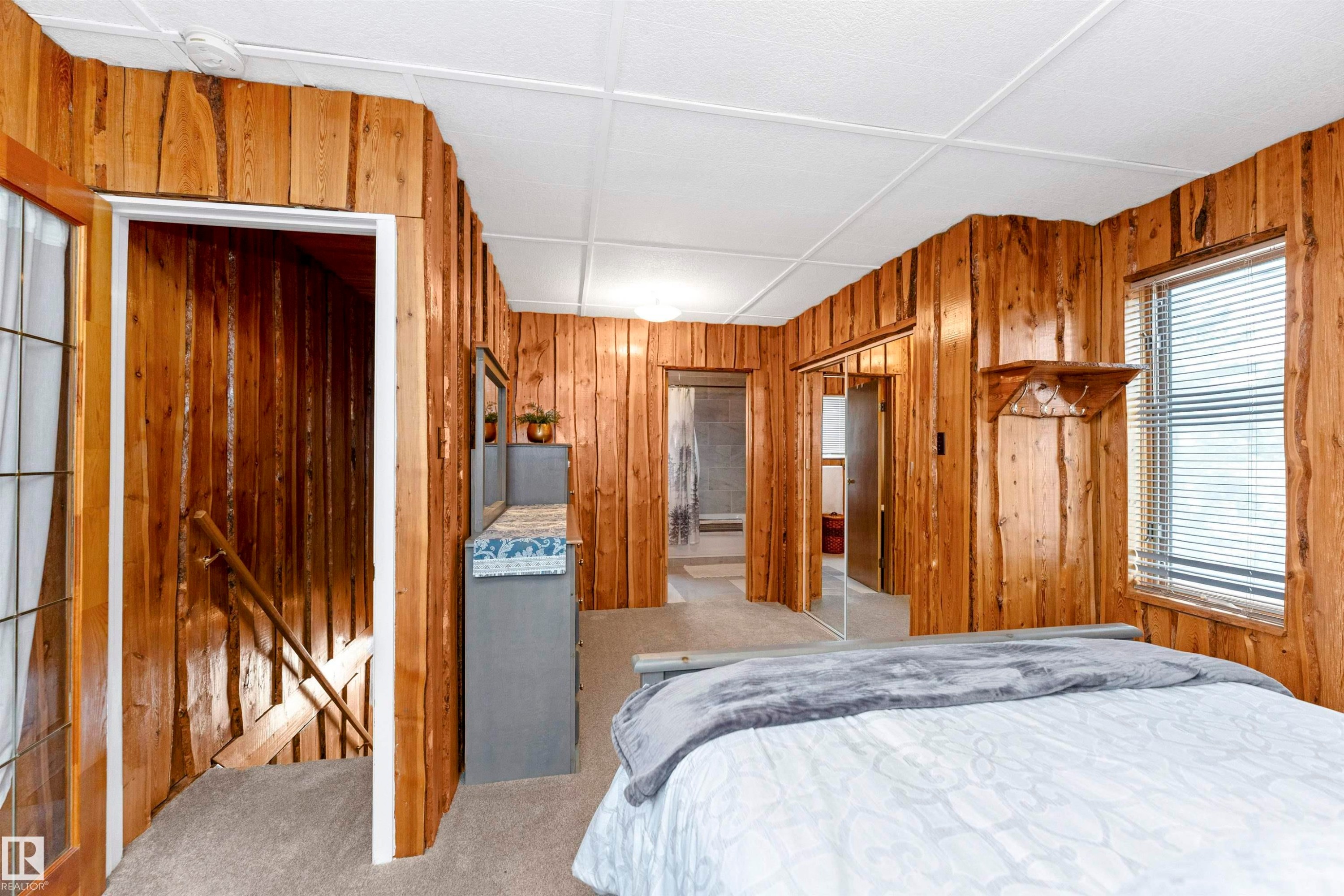 Bathroom featuring wooden walls, shower / bathtub combination with curtain, light tile patterned floors, and wood ceiling - 516 5 Street, Rural Lac Ste. Anne County, AB - Indoor Photo Showing Bathroom