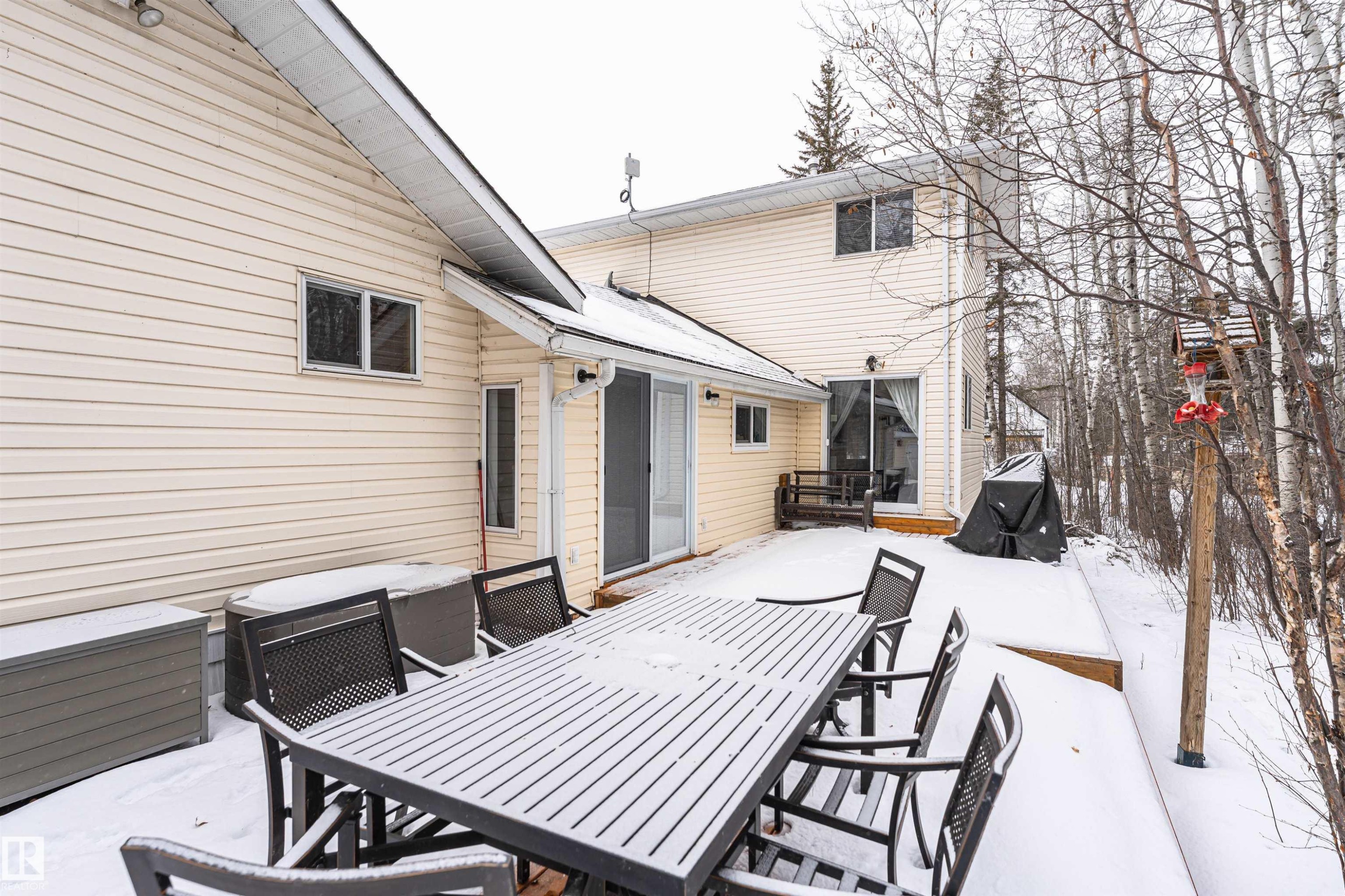 Snow covered patio featuring outdoor dining area and a wooden deck - 516 5 Street, Rural Lac Ste. Anne County, AB - Outdoor With Deck Patio Veranda With Exterior