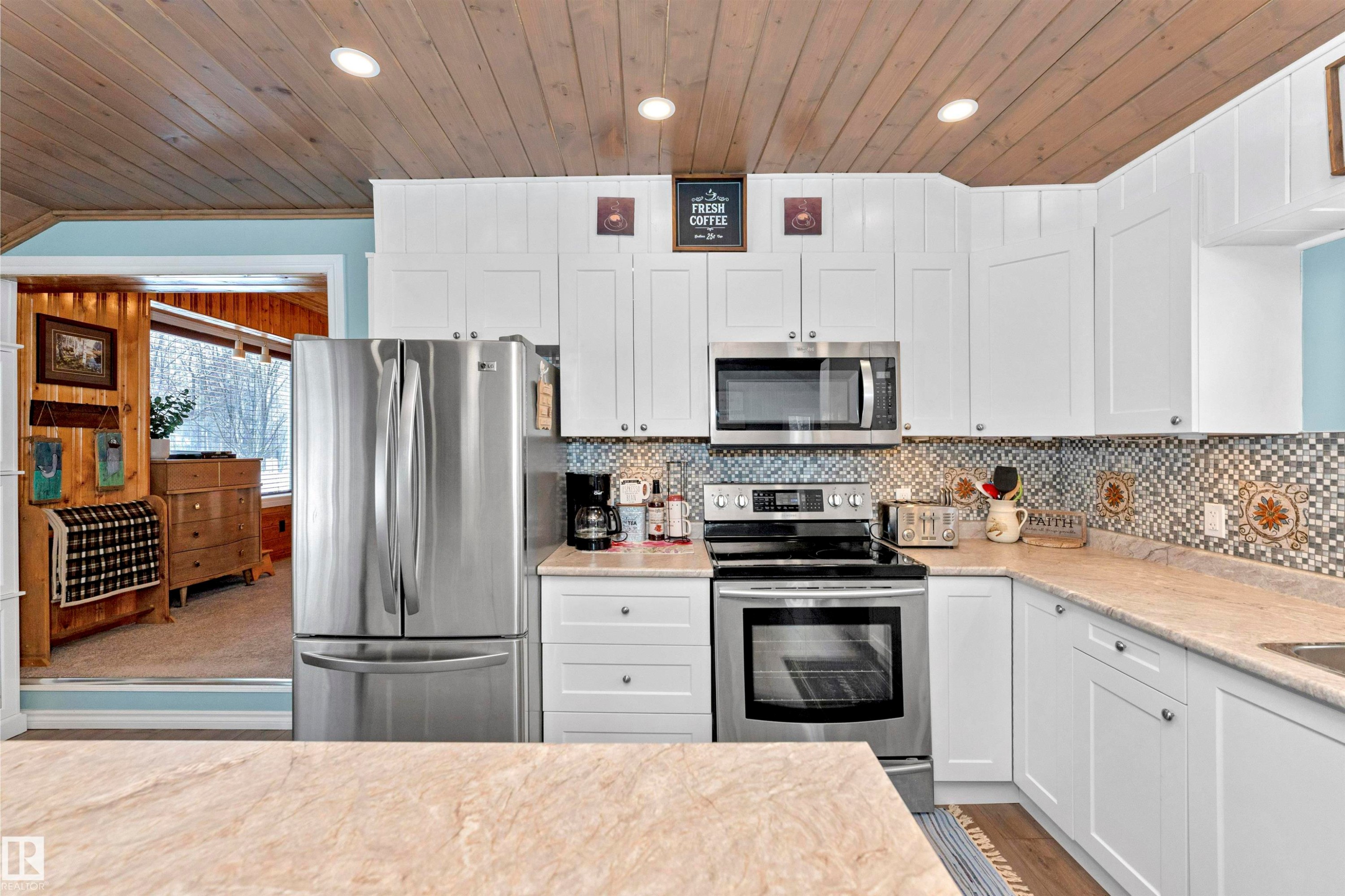Kitchen featuring stainless steel appliances, white cabinetry, a vaulted wood ceiling, light wood-style flooring, and tasteful backsplash - 516 5 Street, Rural Lac Ste. Anne County, AB - Indoor Photo Showing Kitchen