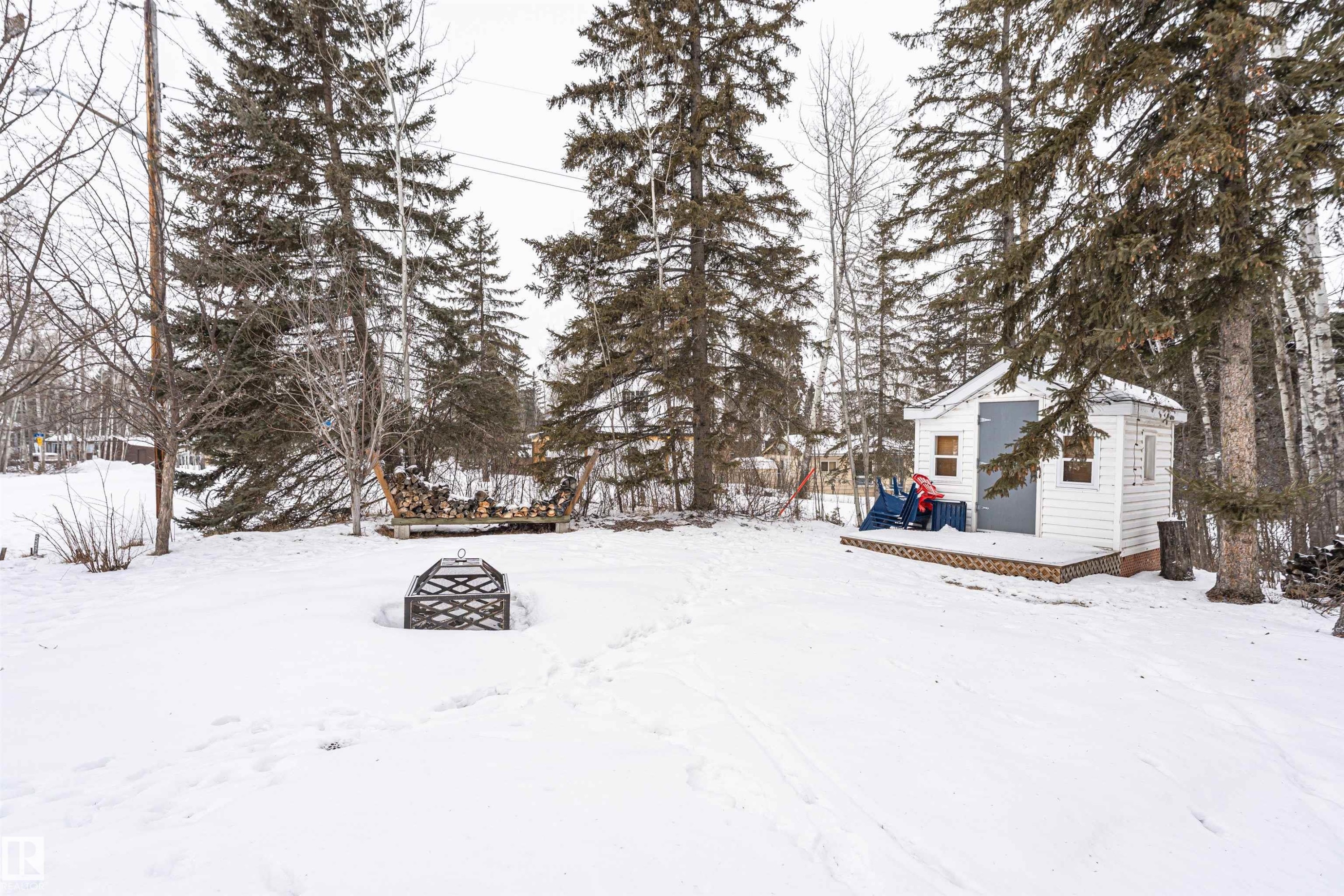 Yard covered in snow featuring a deck, an outbuilding, and a fire pit - 516 5 Street, Rural Lac Ste. Anne County, AB - Outdoor