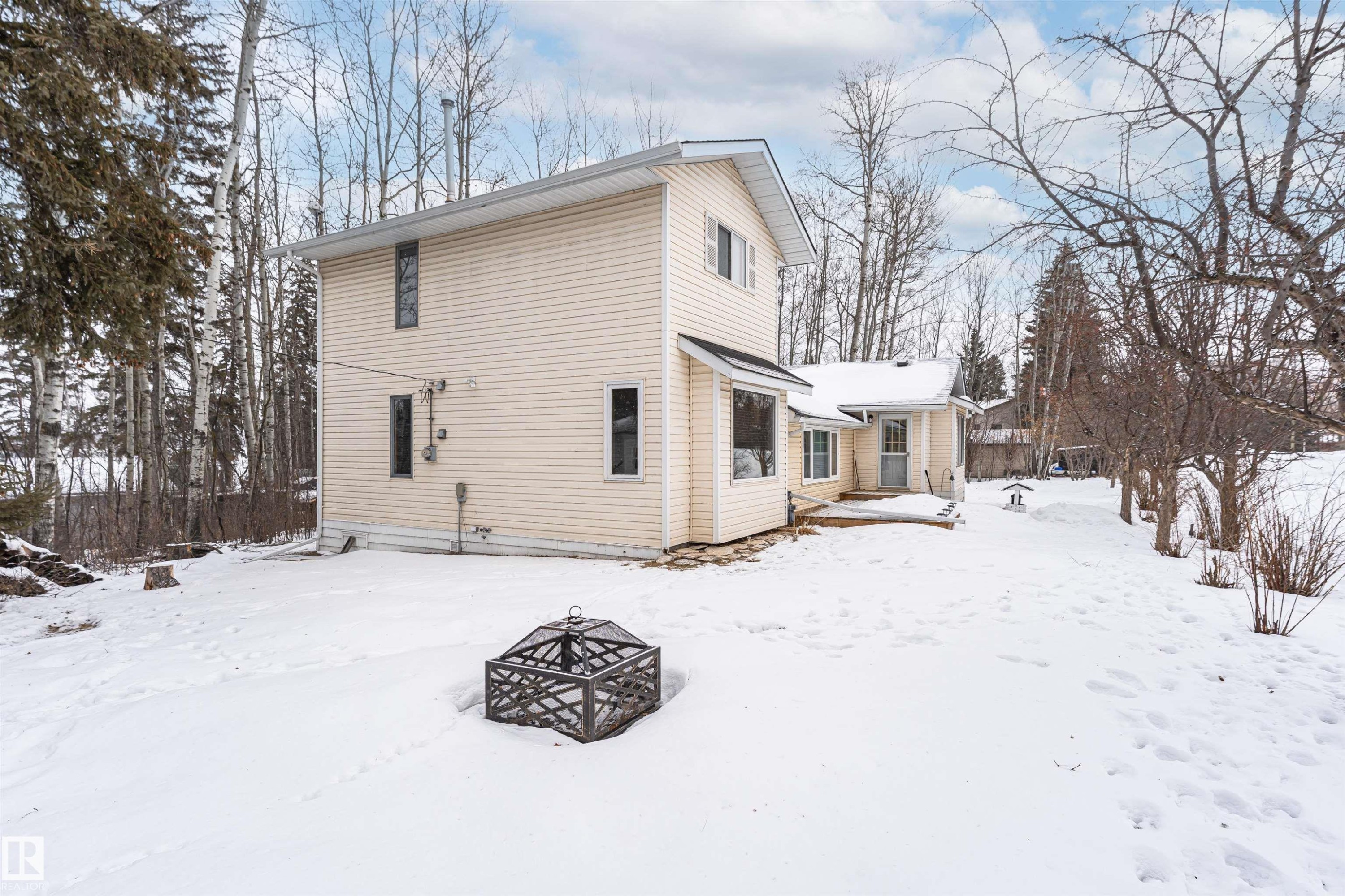 Snow covered back of property featuring an outdoor fire pit - 516 5 Street, Rural Lac Ste. Anne County, AB - Outdoor