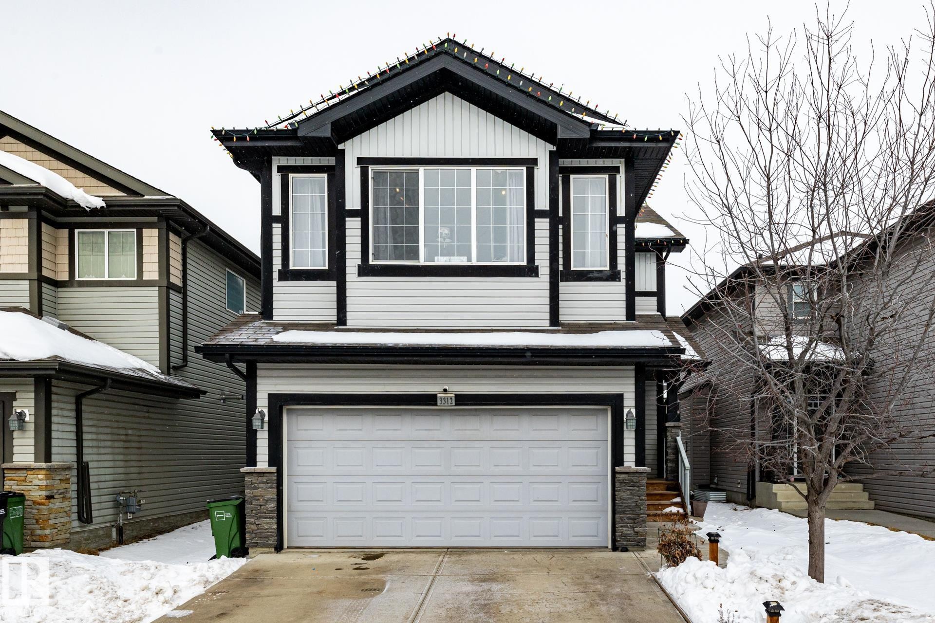 View of front of property with stone siding, driveway, and an attached garage - 3312 17B Avenue, Edmonton, AB - Outdoor
