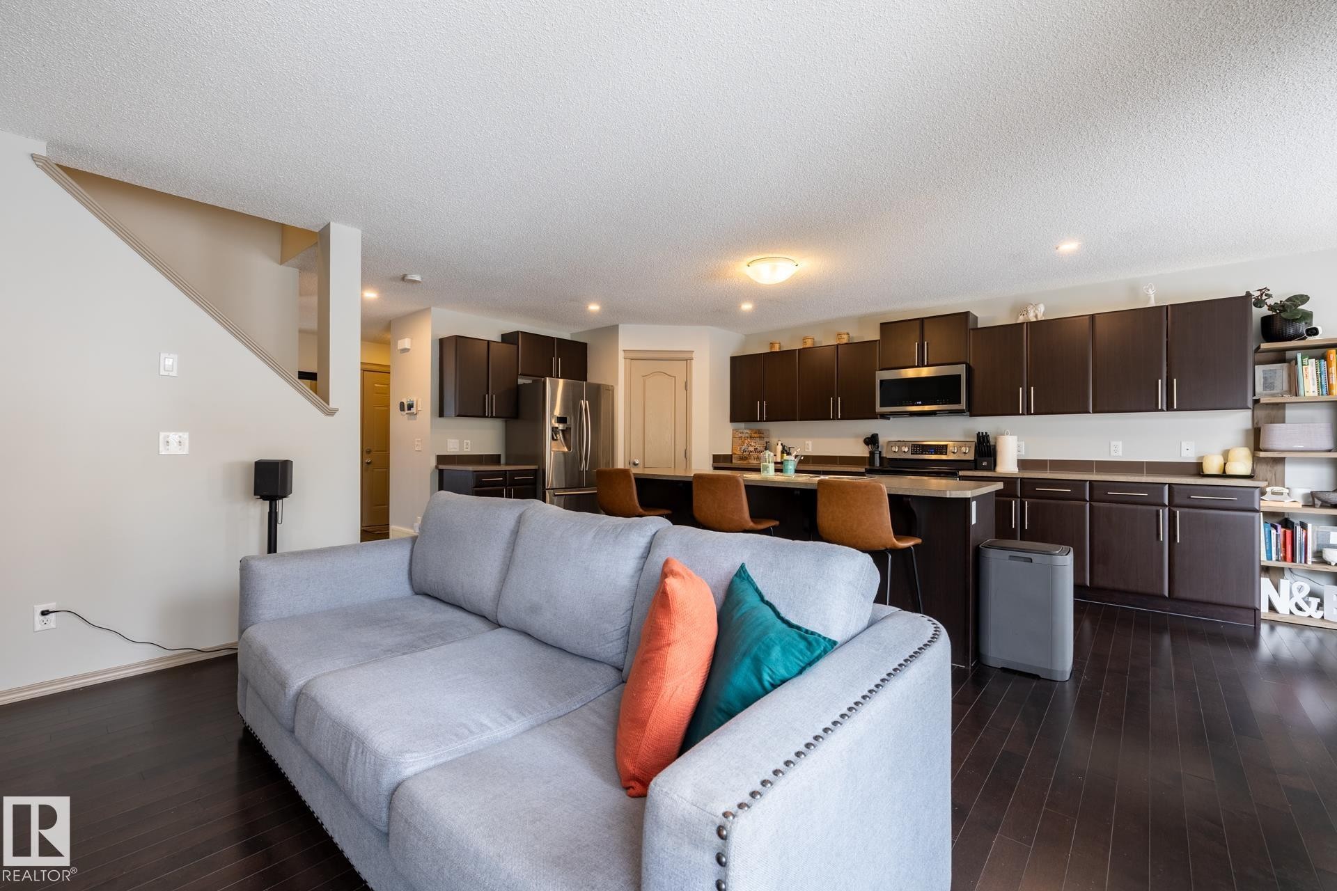 Living room featuring dark wood-style flooring and a textured ceiling - 3312 17B Avenue, Edmonton, AB - Indoor Photo Showing Other Room