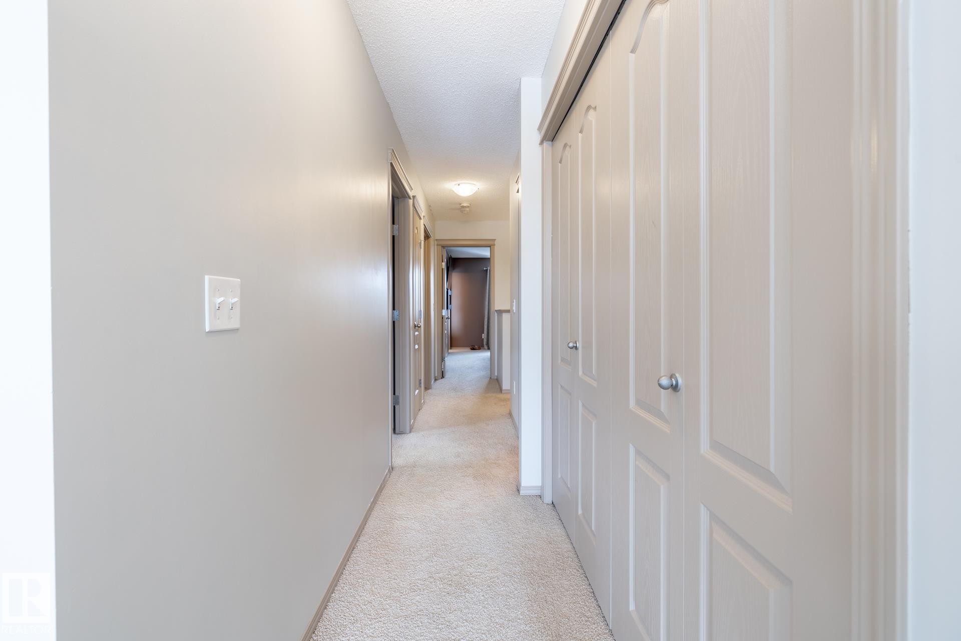 Hallway with light carpet and a textured ceiling - 3312 17B Avenue, Edmonton, AB - Indoor Photo Showing Other Room