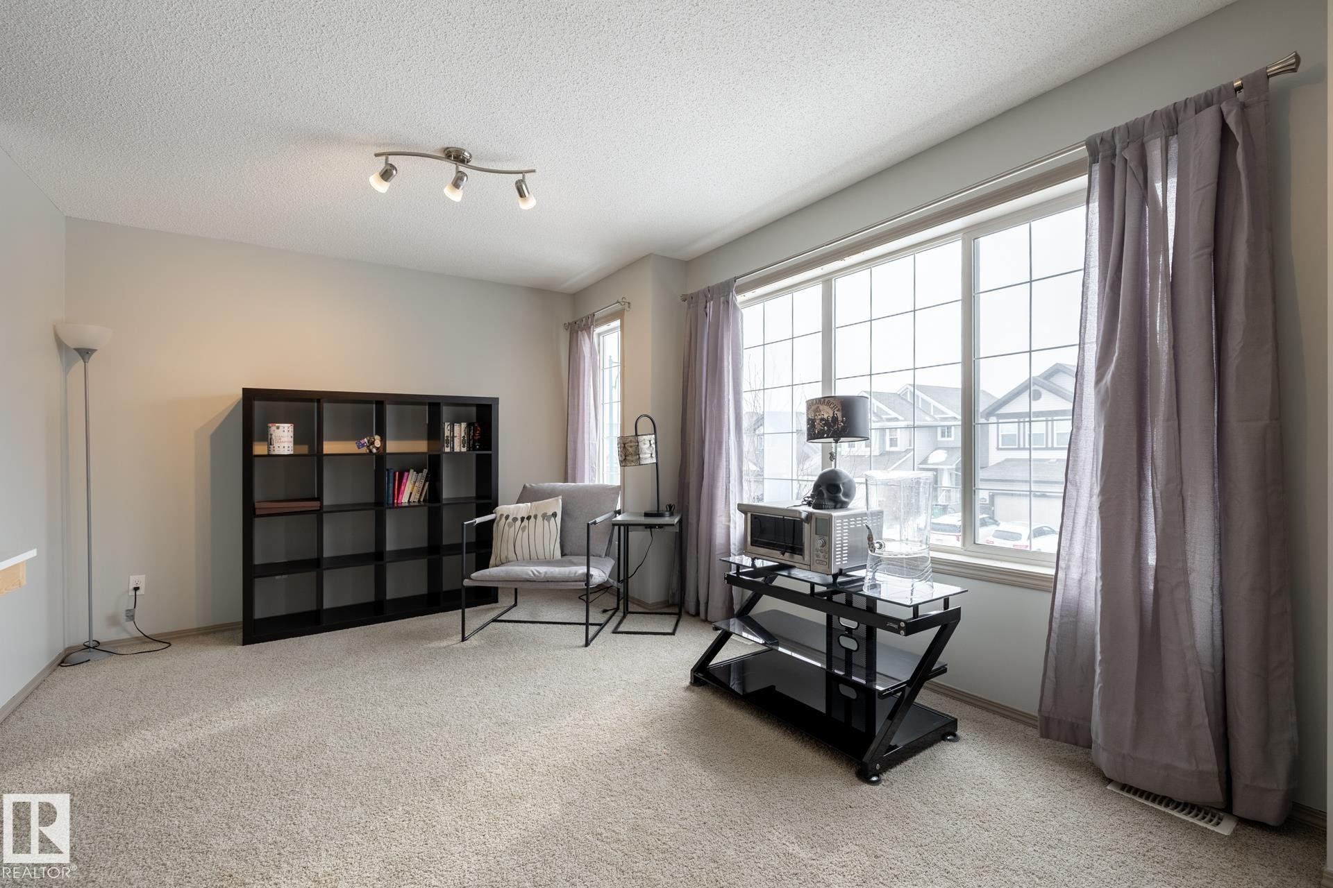 Sitting room featuring light colored carpet and a textured ceiling - 3312 17B Avenue, Edmonton, AB - Indoor