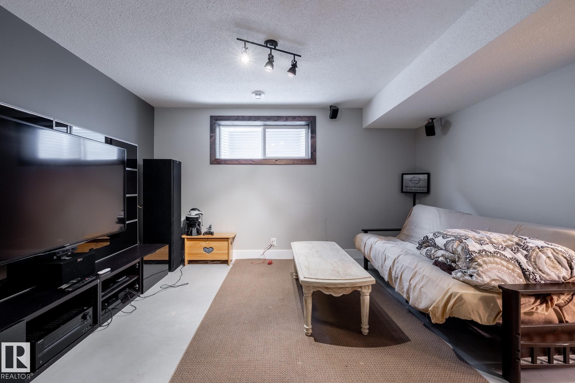 Bedroom with a textured ceiling, concrete flooring, and rail lighting - 3312 17B Avenue, Edmonton, AB - Indoor Photo Showing Bedroom