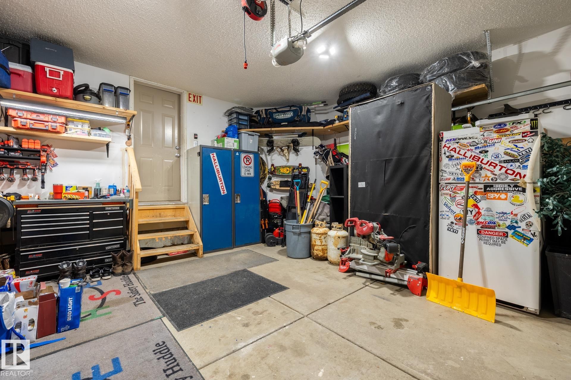 Garage with a workshop area, freestanding refrigerator, and a garage door opener - 3312 17B Avenue, Edmonton, AB - Indoor