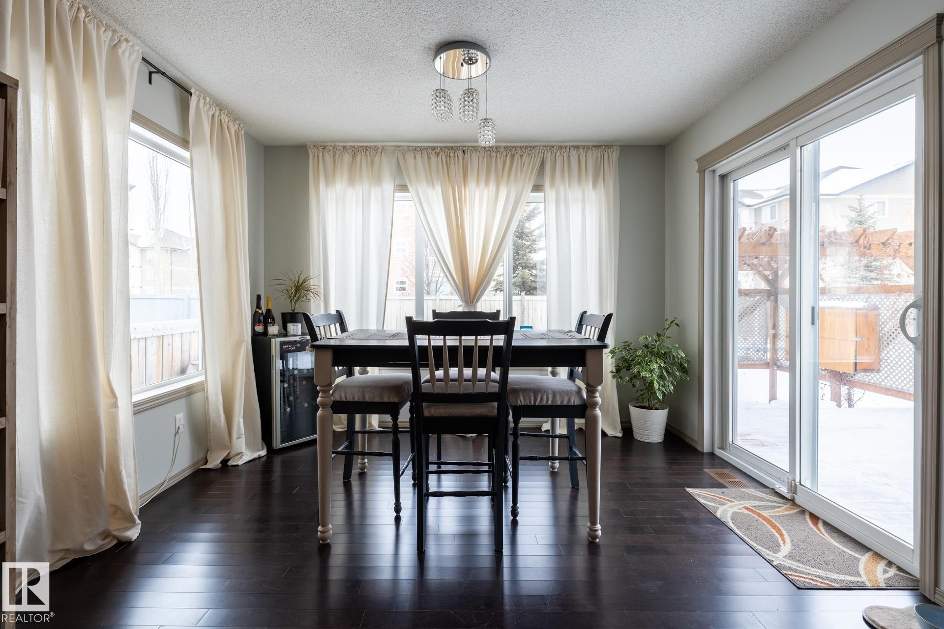 Dining area featuring a textured ceiling, dark wood-type flooring, and plenty of natural light - 3312 17B Avenue, Edmonton, AB - Indoor Photo Showing Dining Room