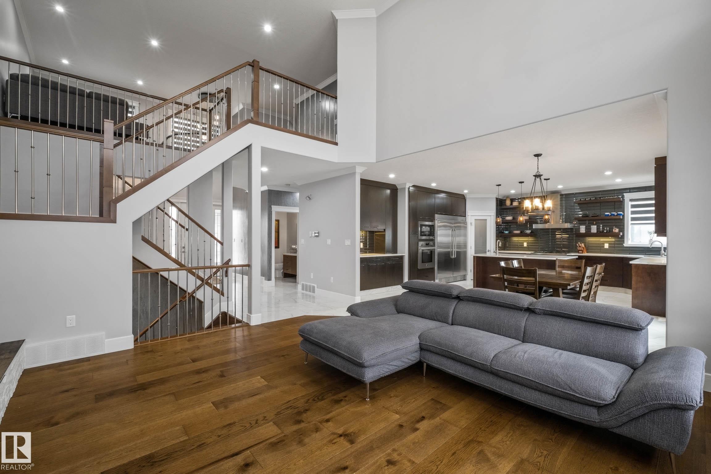 Living room with dark wood-style flooring, a high ceiling, and a chandelier - 4086 Whispering River Drive, Edmonton, AB - Indoor