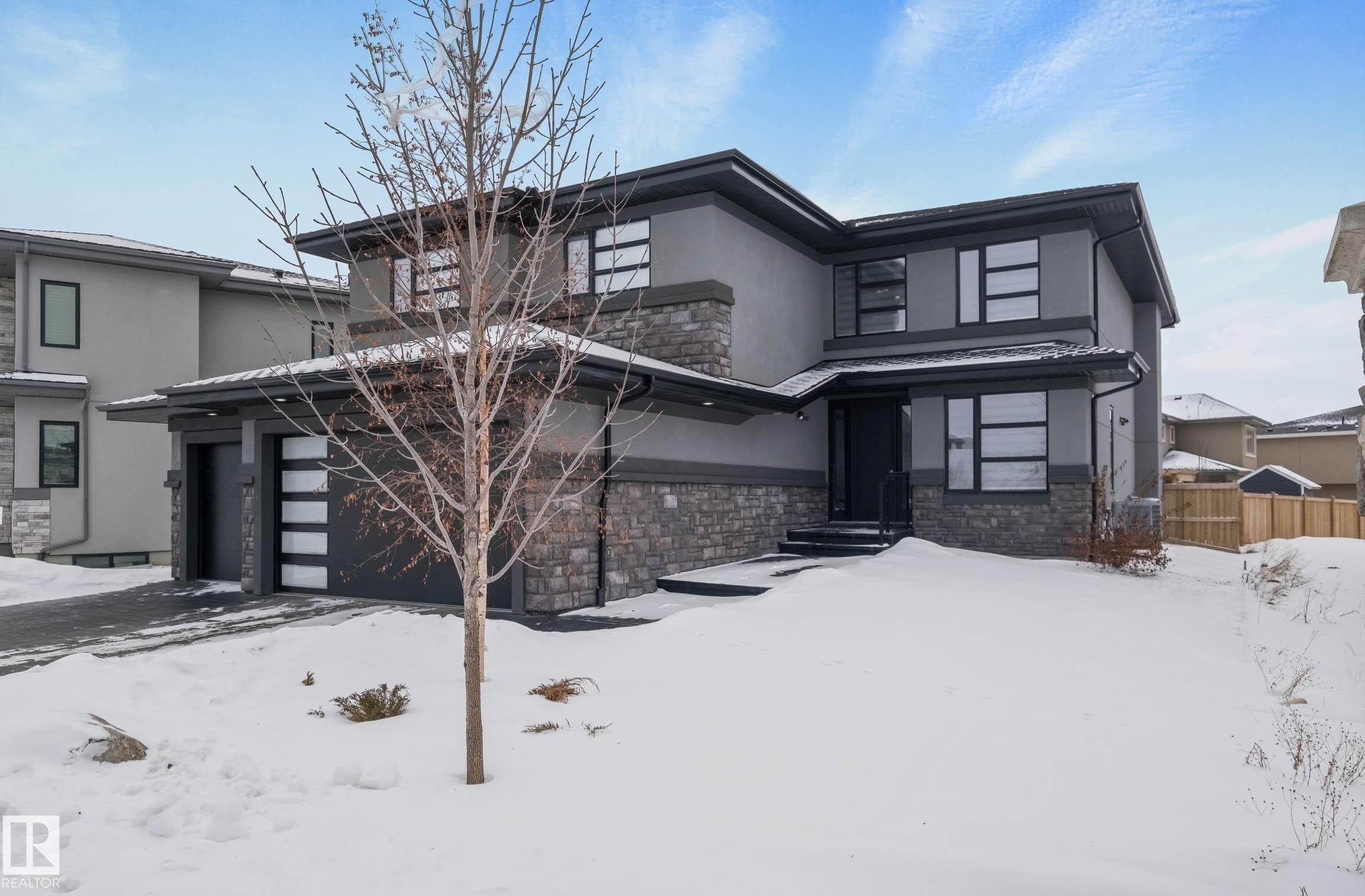 Prairie-style house featuring stone siding, stucco siding, and an attached garage - 4086 Whispering River Drive, Edmonton, AB - Outdoor With Facade