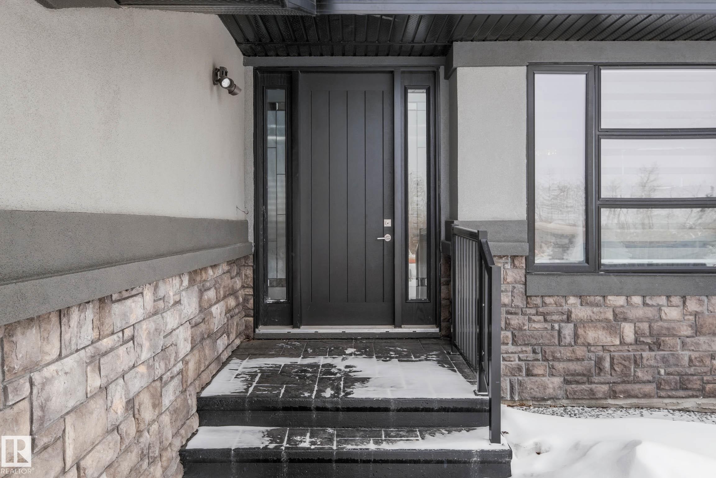 Property entrance with stone siding and stucco siding - 4086 Whispering River Drive, Edmonton, AB - Outdoor