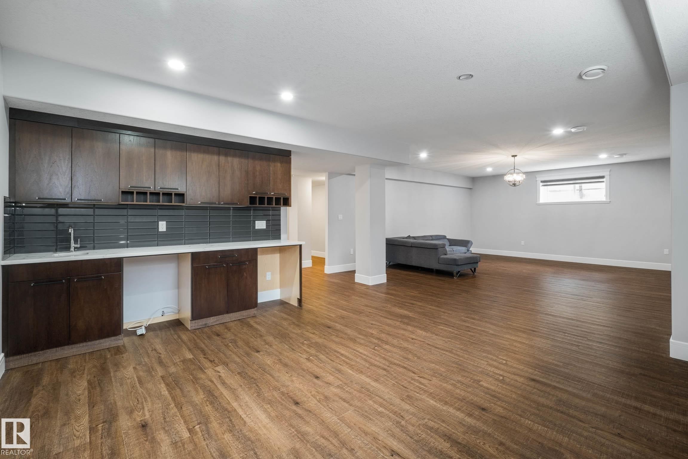 Kitchen with dark wood finish cabinets, decorative backsplash, dark wood-type flooring, open floor plan, and recessed lighting - 4086 Whispering River Drive, Edmonton, AB - Indoor Photo Showing Kitchen