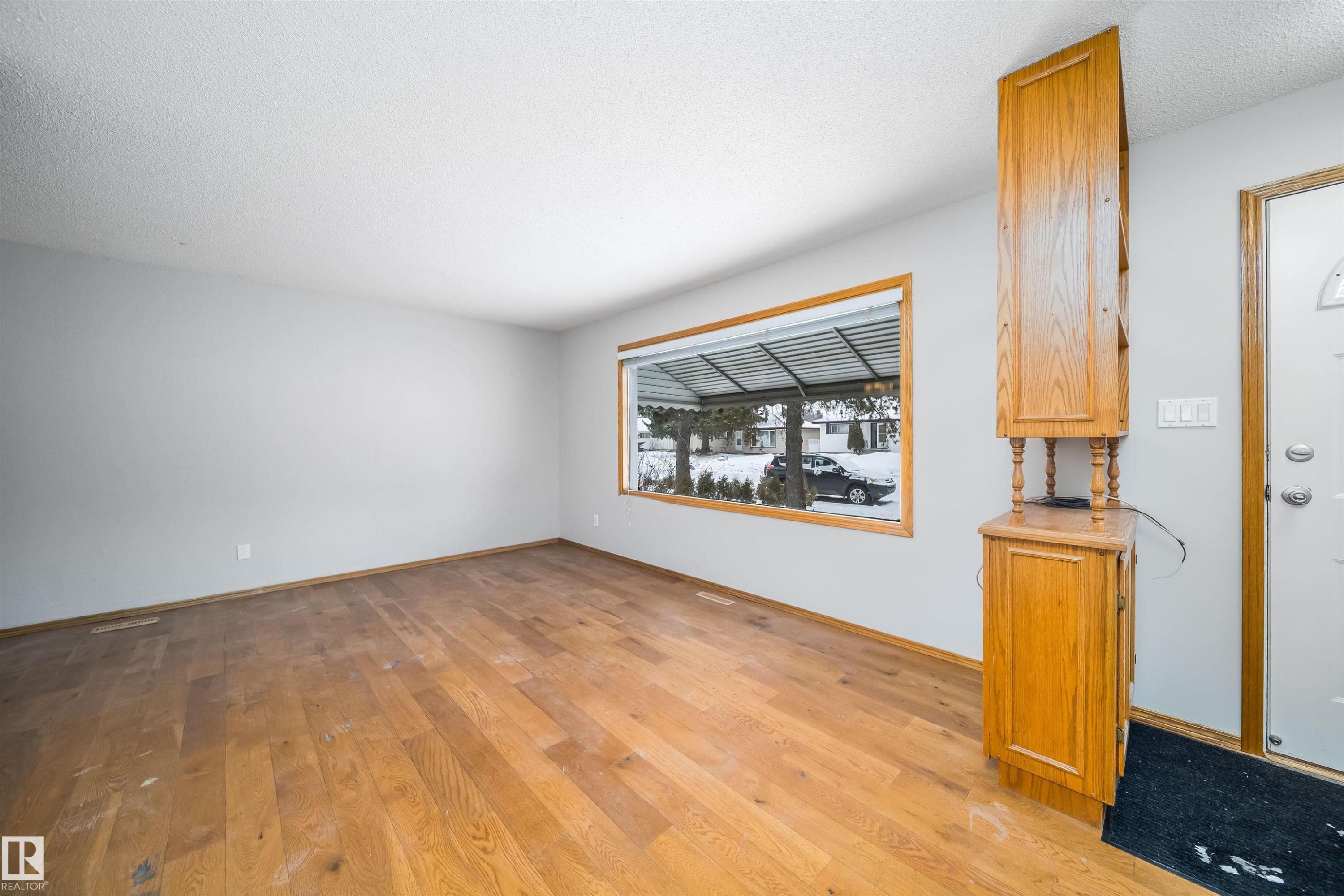 Spare room with light wood-type flooring and a textured ceiling - 8908 130 Avenue Nw, Edmonton, AB - Indoor Photo Showing Living Room