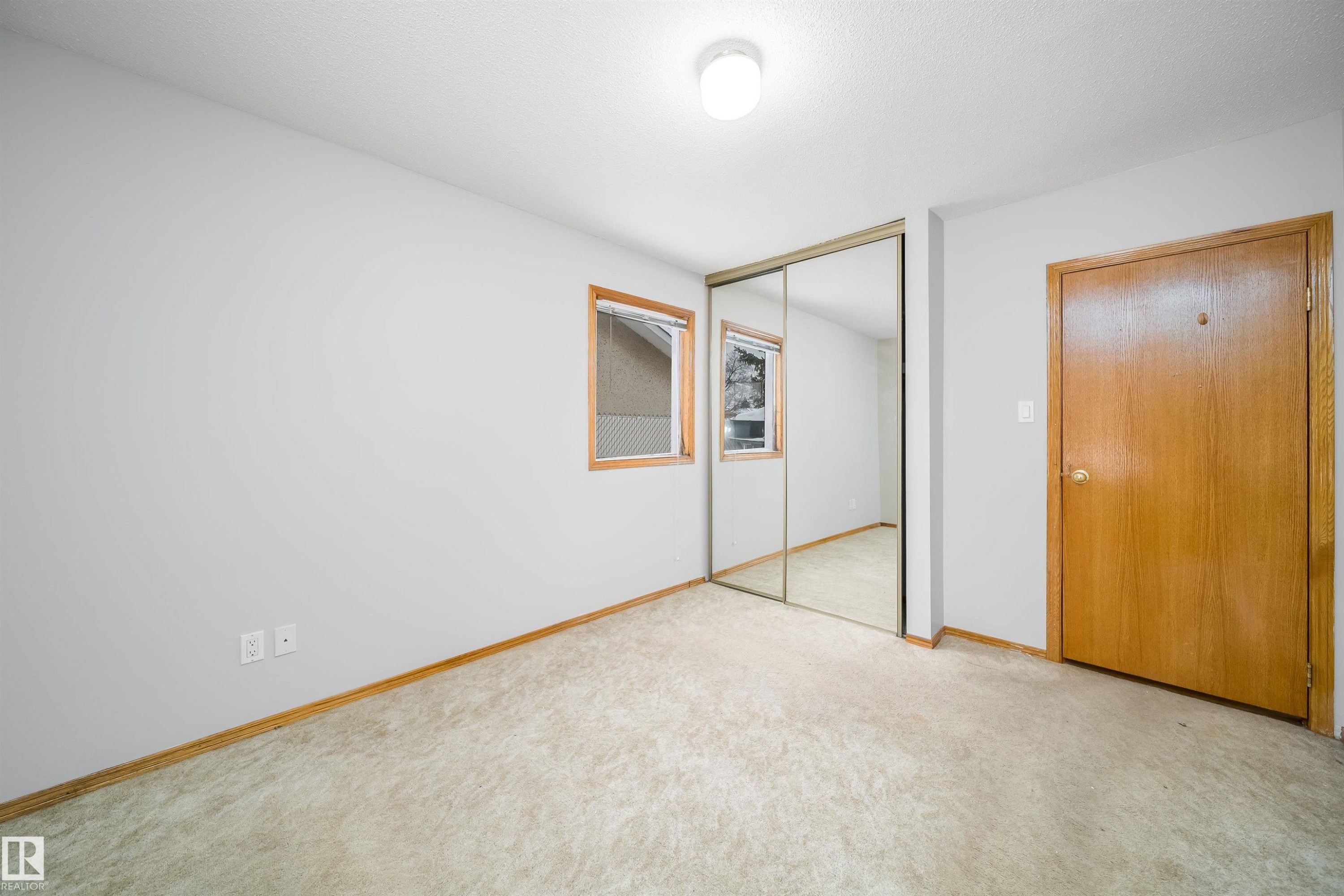 Unfurnished bedroom featuring a closet and light colored carpet - 8908 130 Avenue Nw, Edmonton, AB - Indoor Photo Showing Other Room
