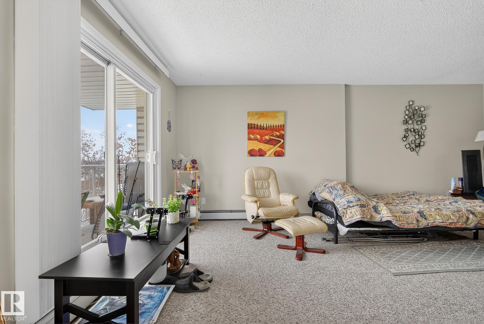 Carpeted bedroom featuring a textured ceiling and a baseboard heating unit - 302 4608 52 Avenue, Stony Plain, AB - Indoor
