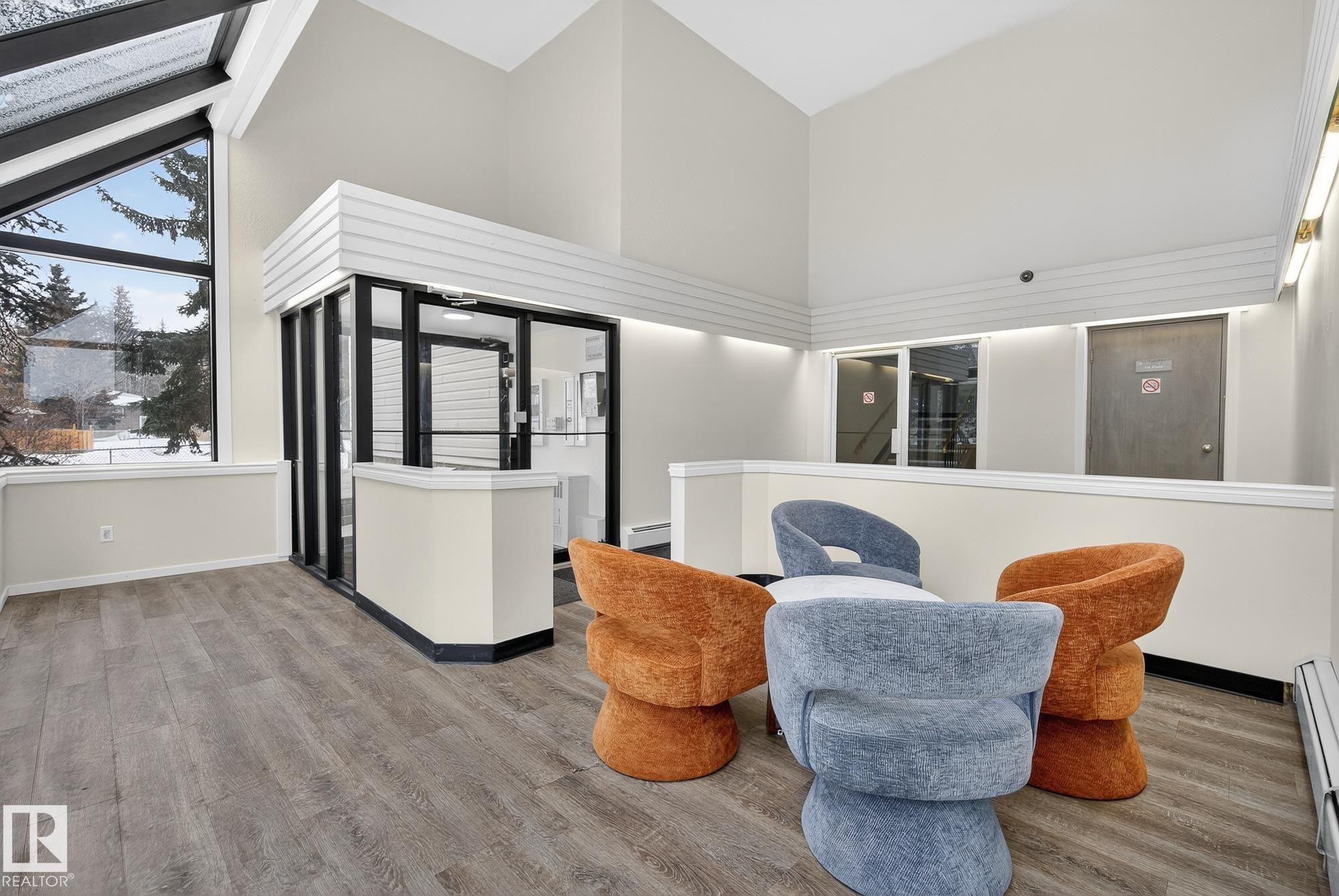 Living area with lofted ceiling and a baseboard heating unit - 302 4608 52 Avenue, Stony Plain, AB - Indoor Photo Showing Other Room