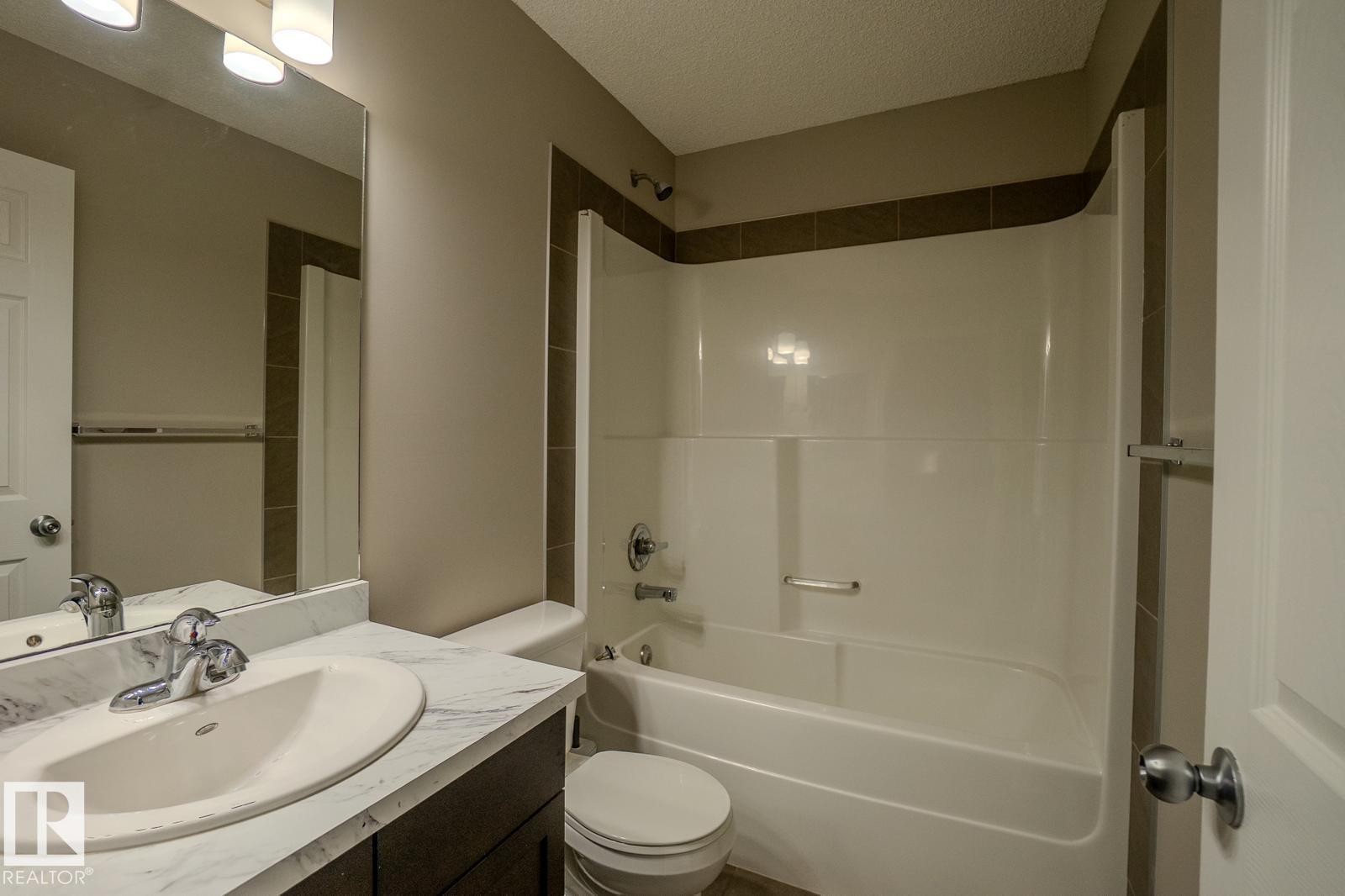 Full bath with vanity, bathtub / shower combination, and a textured ceiling - Edmonton, AB - Indoor Photo Showing Bathroom