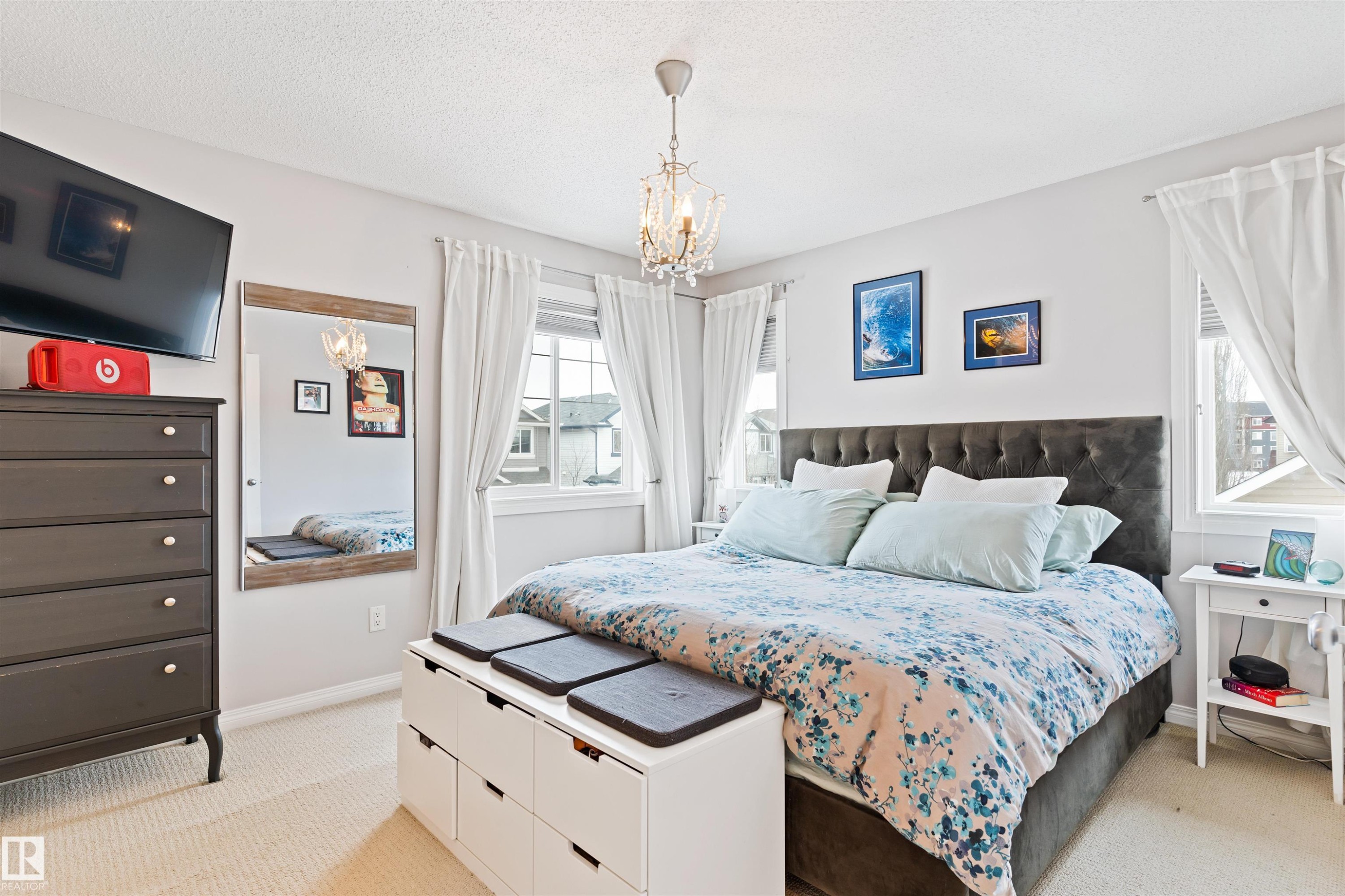 Bedroom featuring suspended lighting, light carpet, and a textured ceiling - 7804 Schmid Place, Edmonton, AB - Indoor Photo Showing Bedroom