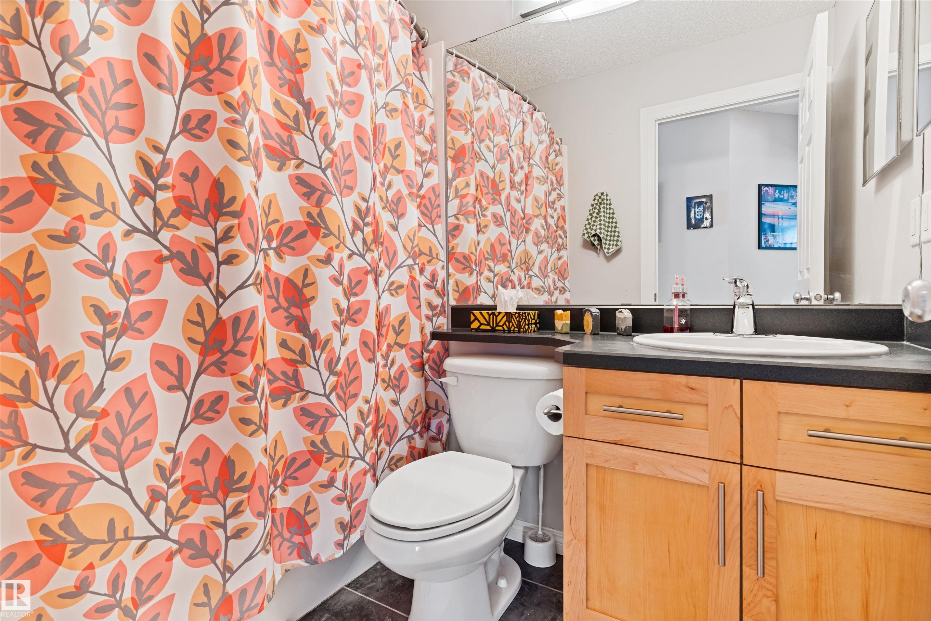 Full bath with a shower with curtain, vanity, and dark tile patterned flooring - 7804 Schmid Place, Edmonton, AB - Indoor Photo Showing Bathroom