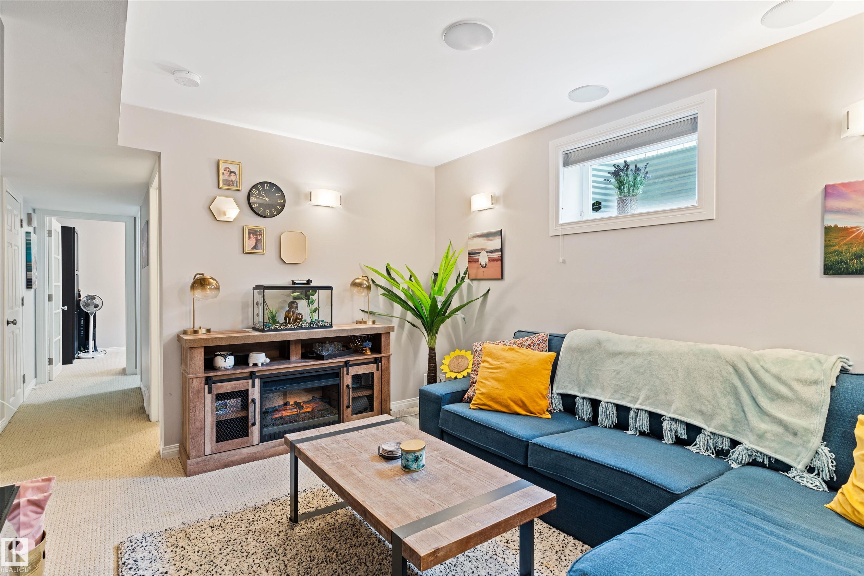 Living room featuring carpet floors and a glass covered fireplace - 7804 Schmid Place, Edmonton, AB - Indoor Photo Showing Other Room