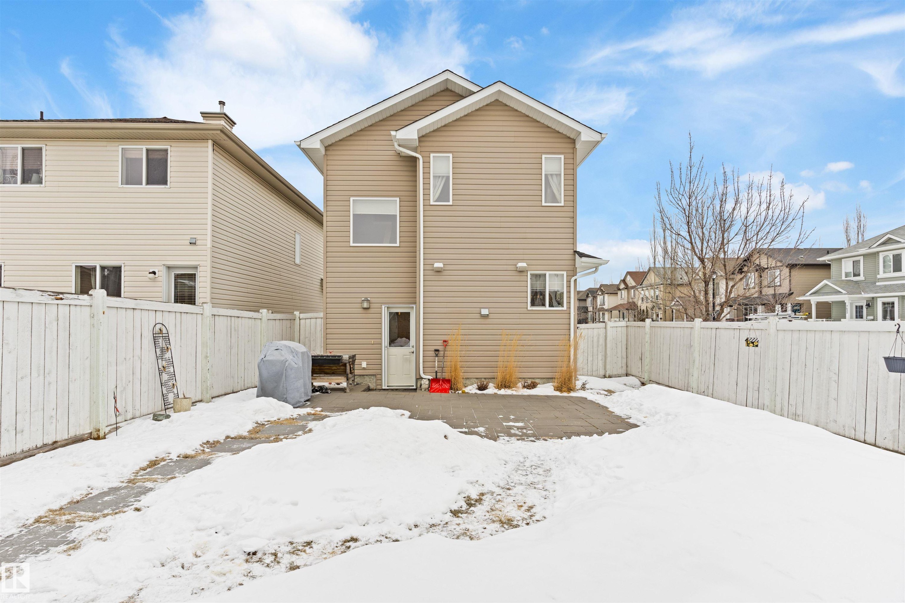 Snow covered property with a patio area, a fenced backyard, and a residential view - 7804 Schmid Place, Edmonton, AB - Outdoor