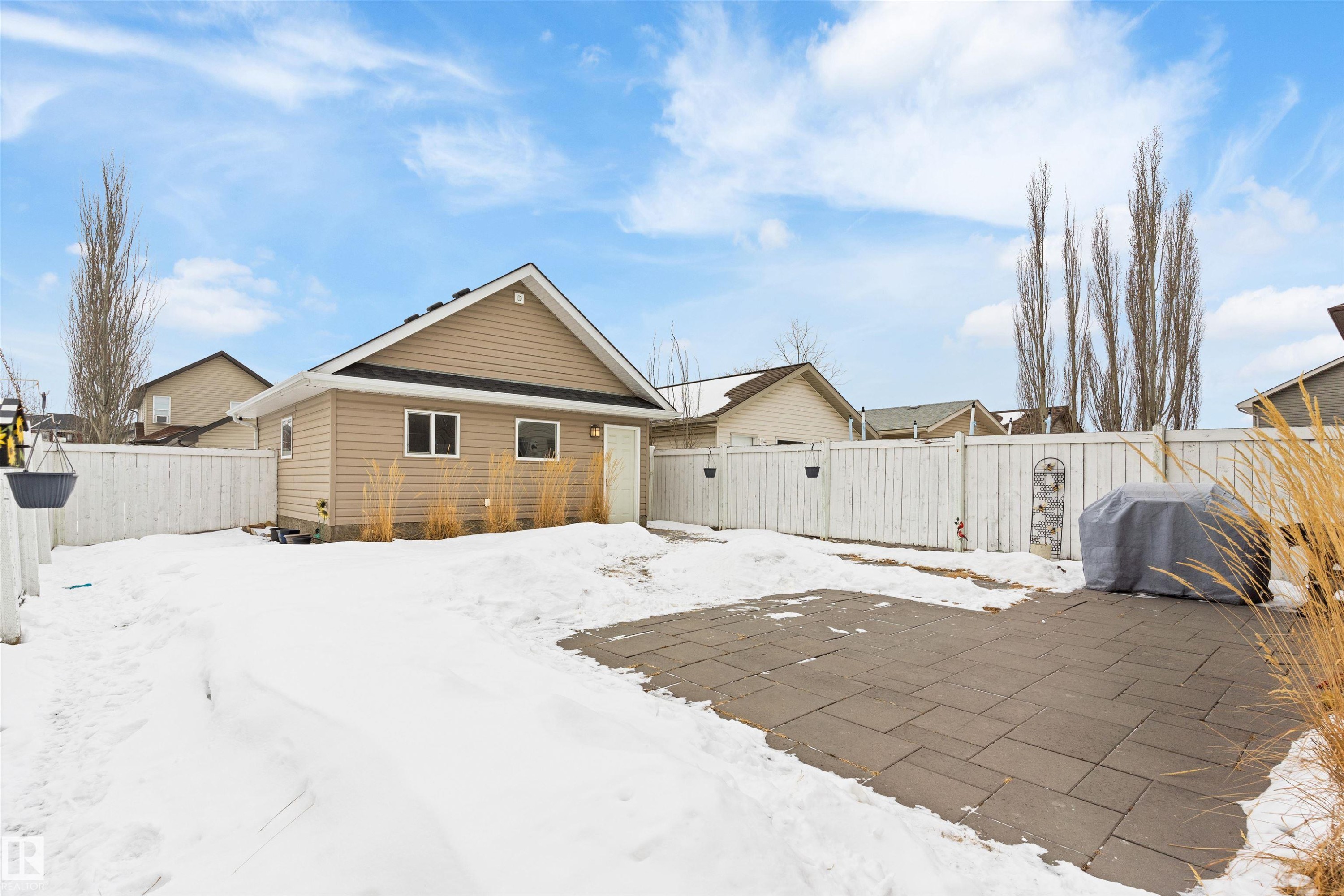 Snow covered back of property with a fenced backyard and a patio - 7804 Schmid Place, Edmonton, AB - Outdoor