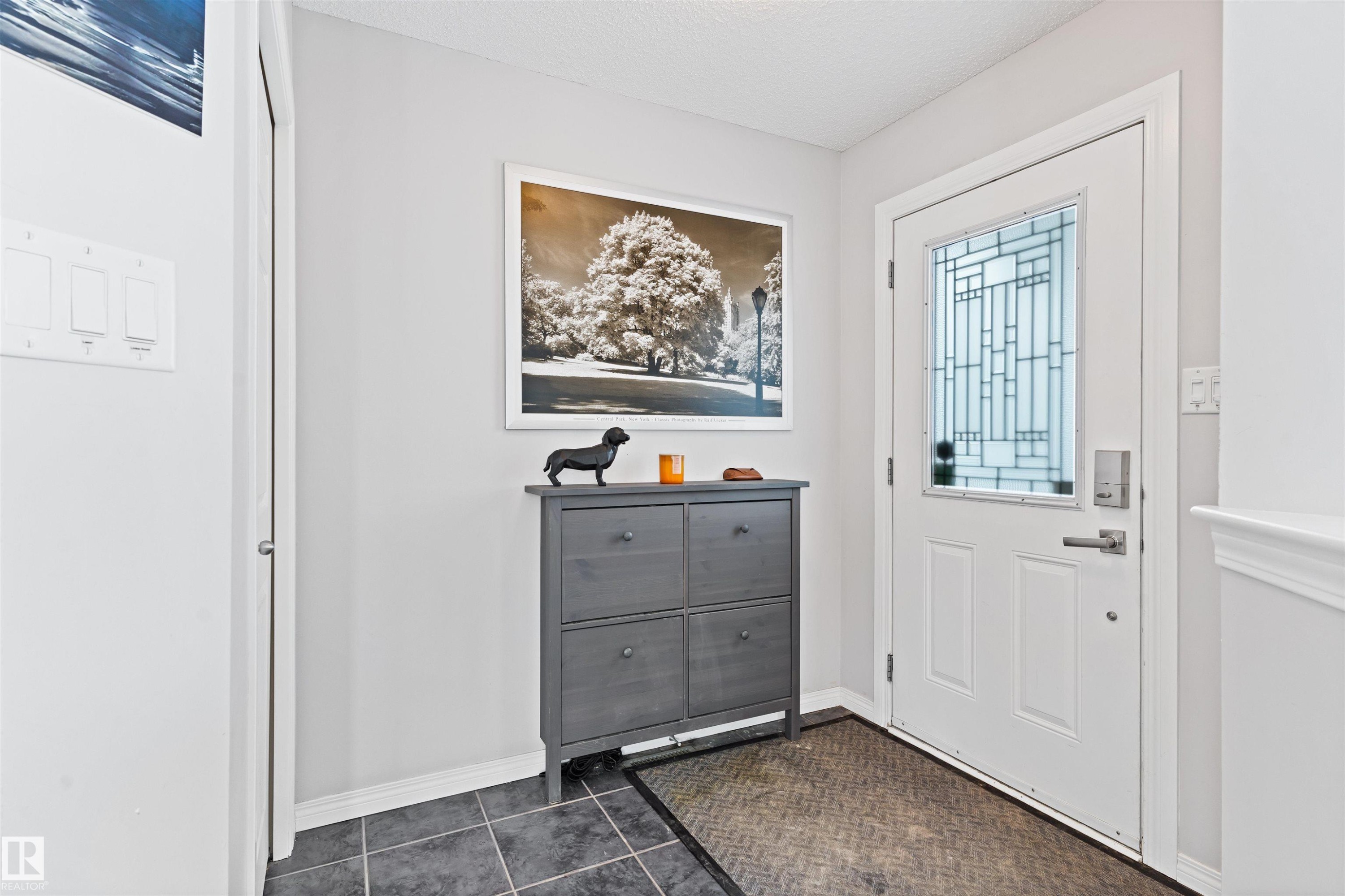 Entryway with dark tile patterned flooring and a textured ceiling - 7804 Schmid Place, Edmonton, AB - Indoor Photo Showing Other Room