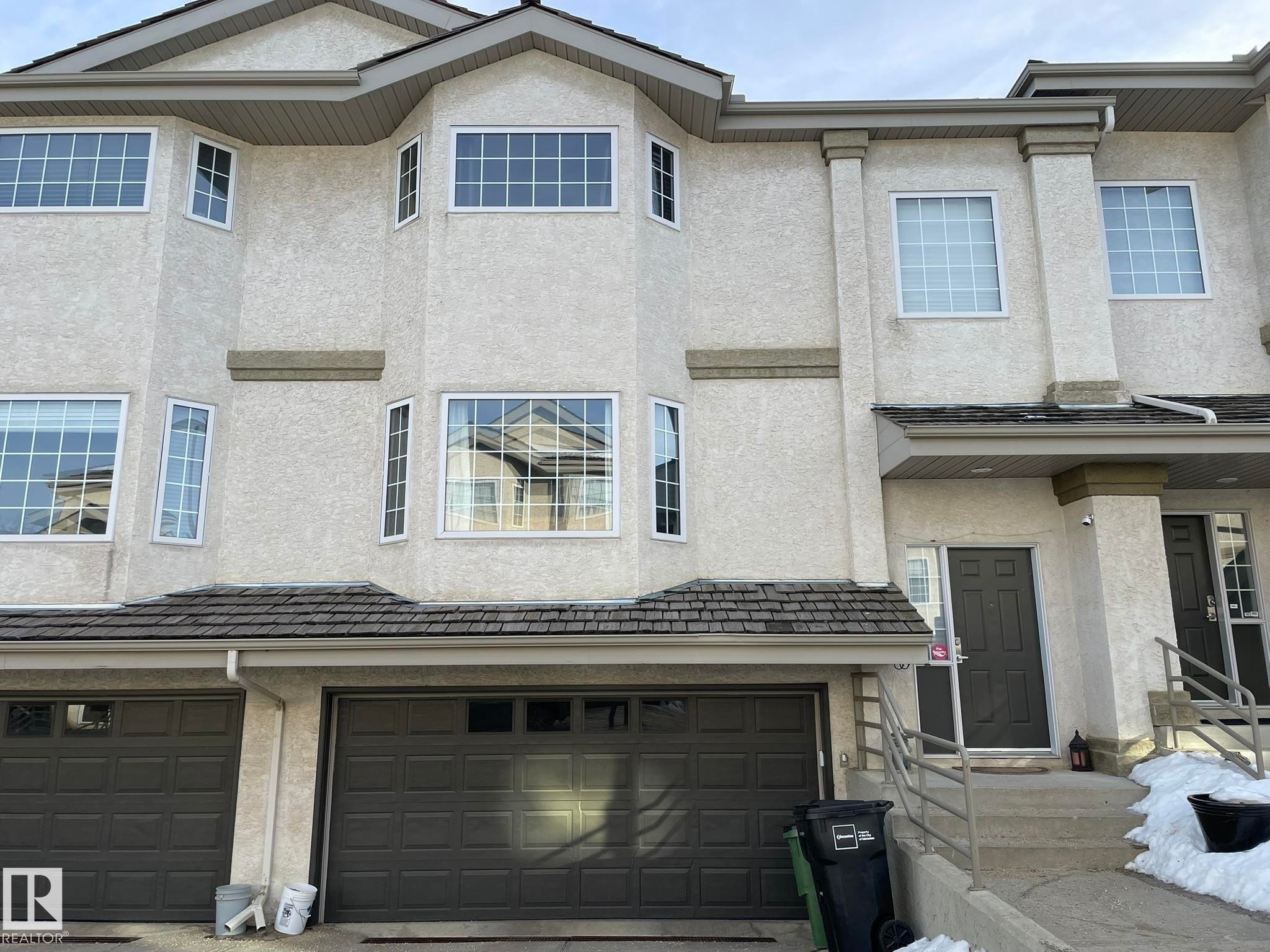 View of front facade with stucco siding and an attached garage - 2 1295 Carter Crest Road, Edmonton, AB - Outdoor