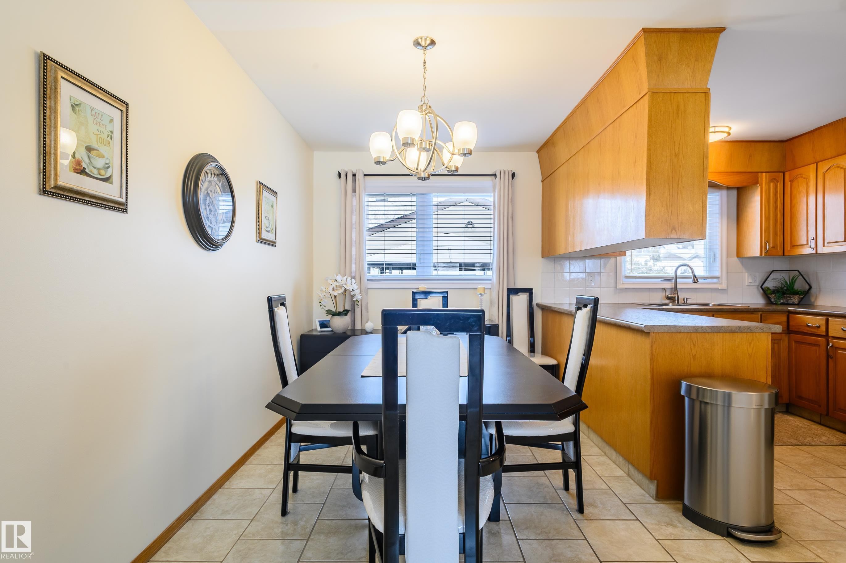 Dining area featuring healthy amount of natural light, hanging lights, and light tile patterned floors - 13420 113A St, Edmonton, AB - Indoor