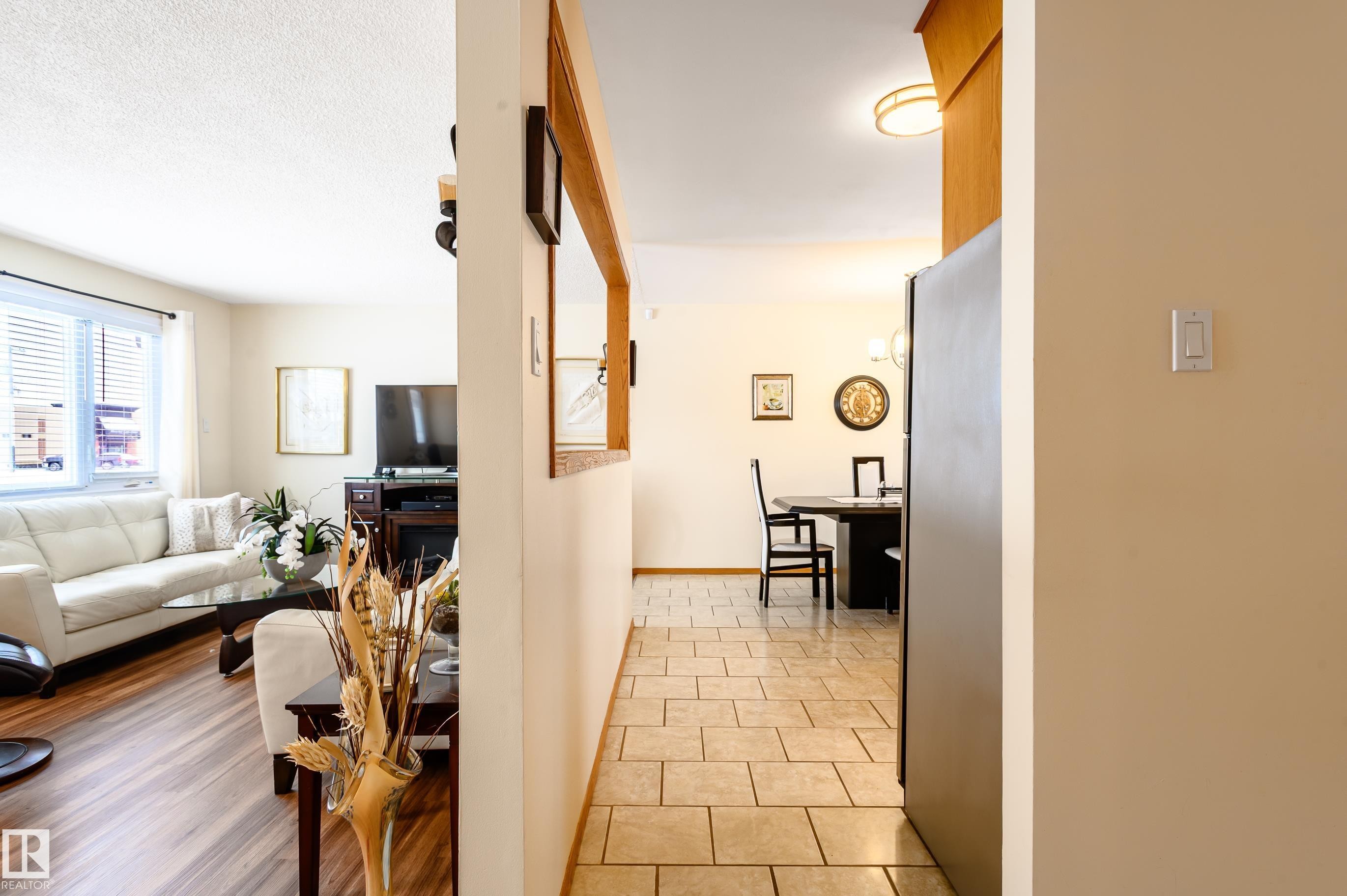 Hall with light tile patterned floors and baseboards - 13420 113A St, Edmonton, AB - Indoor Photo Showing Other Room
