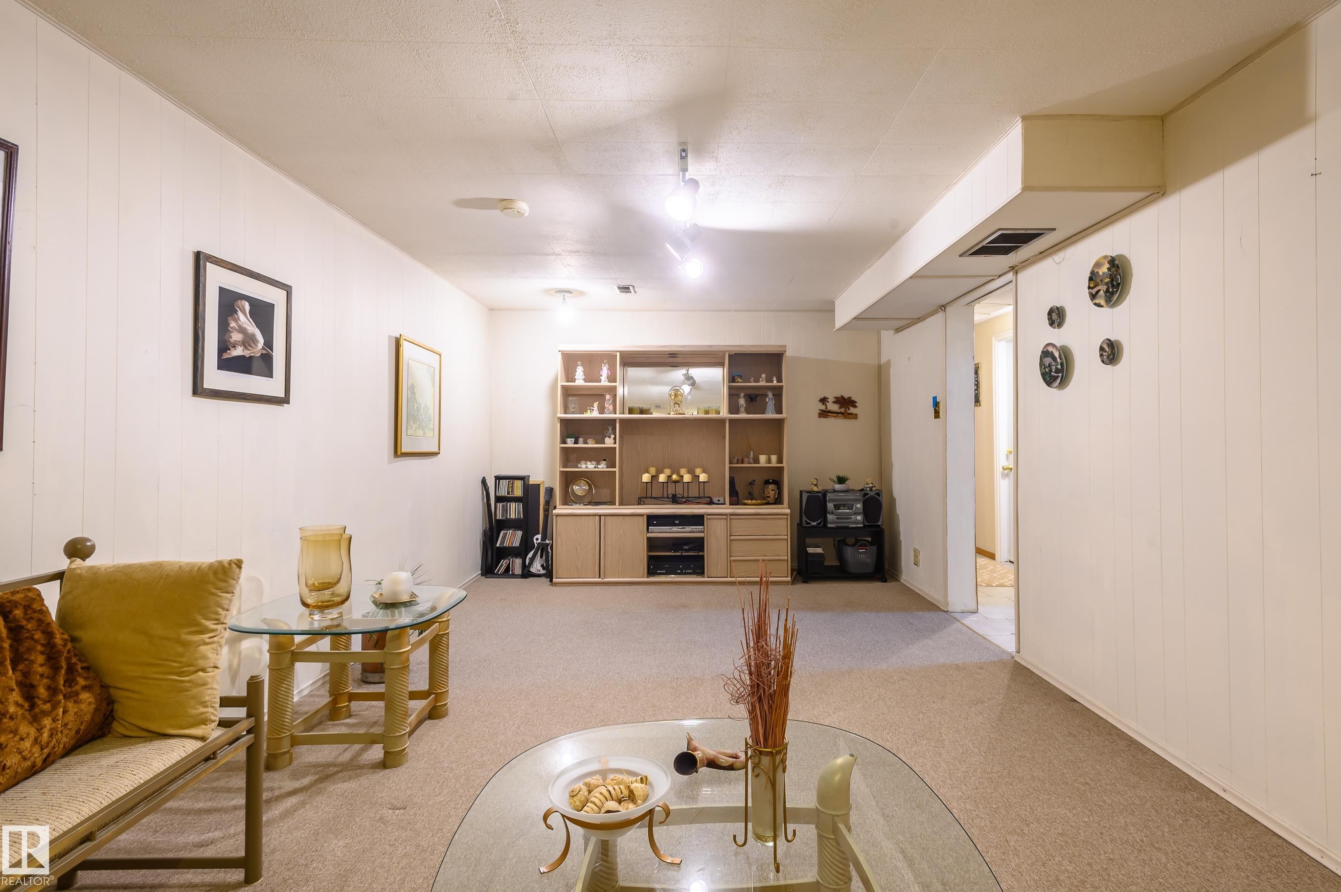 Sitting room with wooden walls, light colored carpet, and a dry bar - 13420 113A St, Edmonton, AB - Indoor