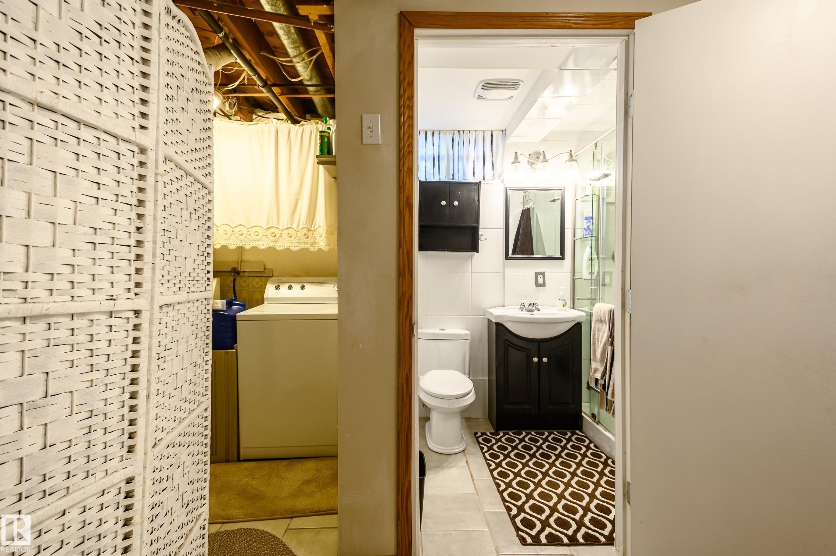 Bathroom with vanity, washer / clothes dryer, and light tile patterned floors - 13420 113A St, Edmonton, AB - Indoor Photo Showing Bathroom