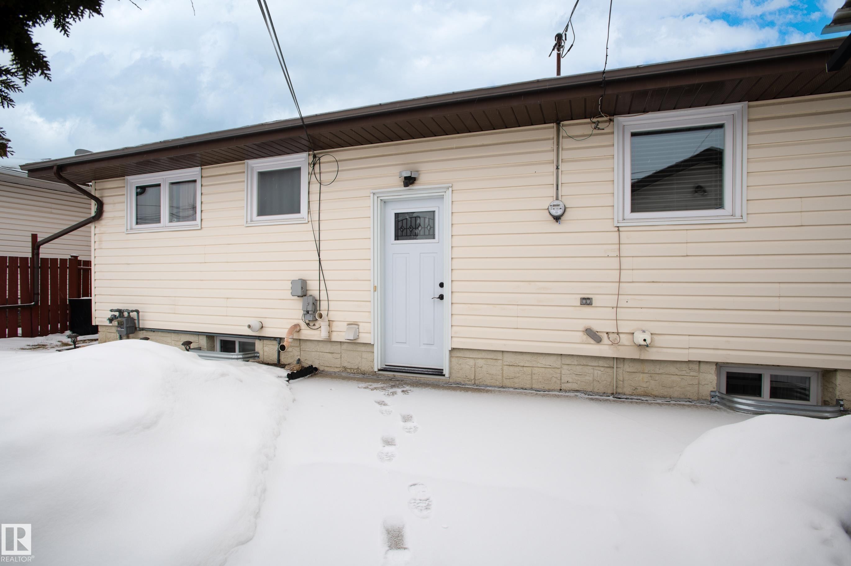 View of snow covered back of property - 13420 113A St, Edmonton, AB - Outdoor With Exterior