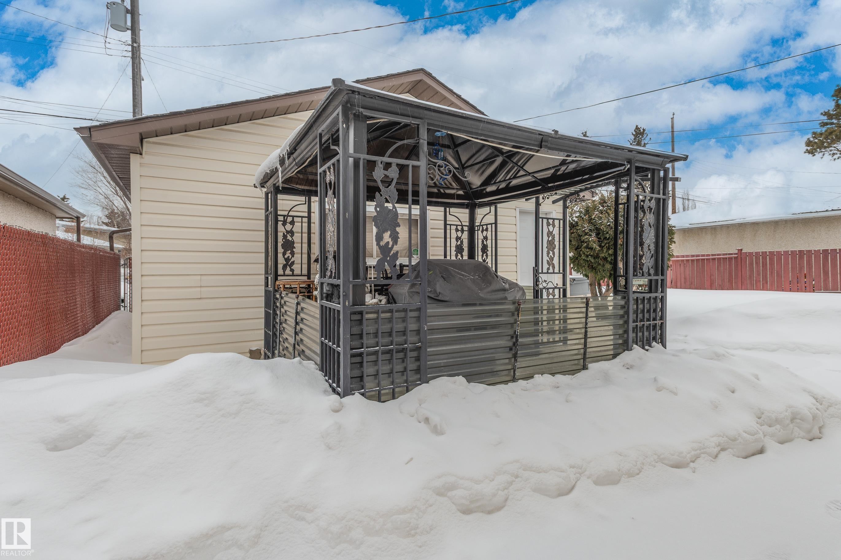 Snow covered house with a deck and a gazebo - 13420 113A St, Edmonton, AB - Outdoor With Exterior