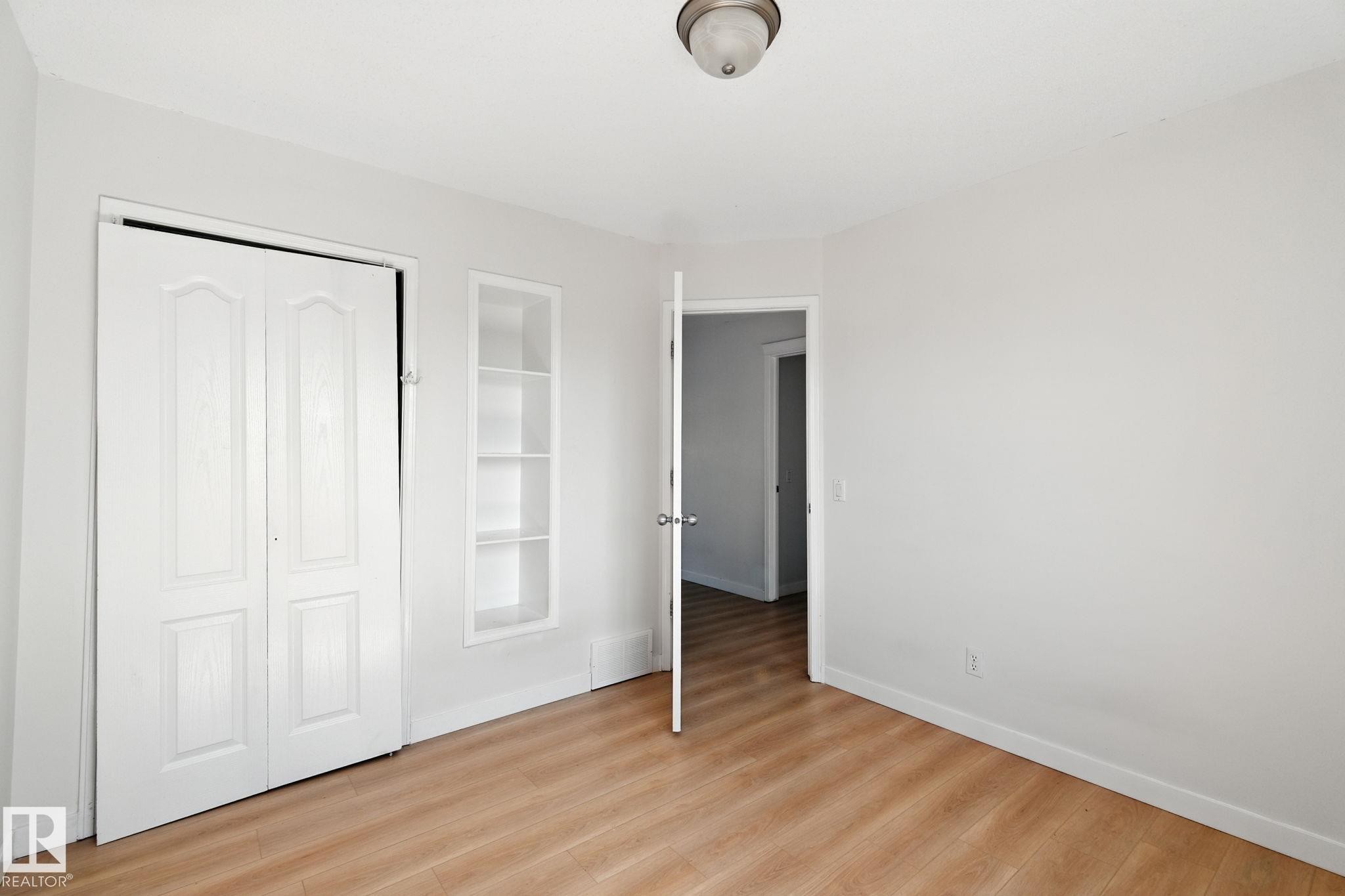 Unfurnished bedroom with light wood finished floors and a closet - 7836 7 Avenue, Edmonton, AB - Indoor