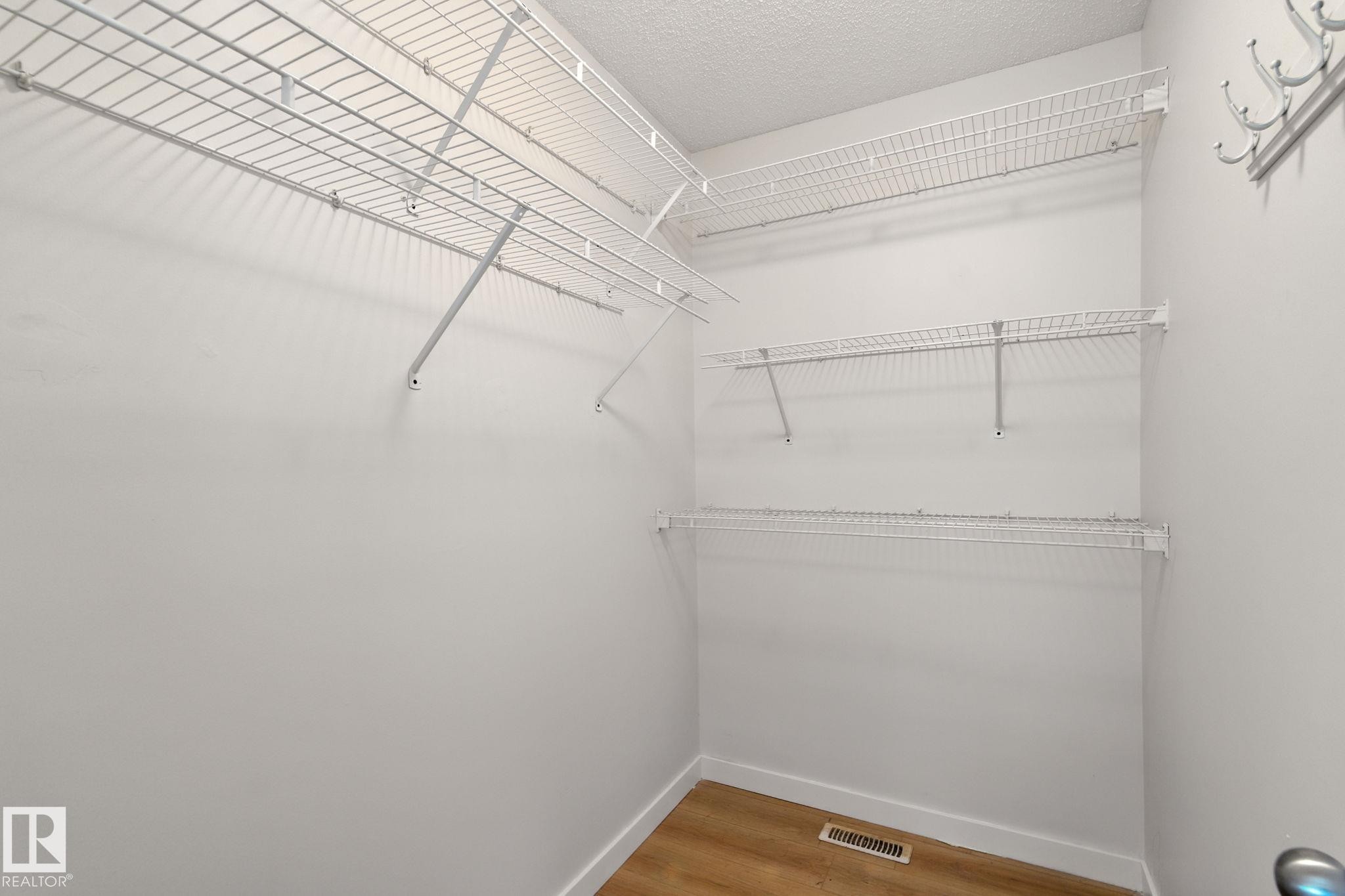 Walk in closet featuring light wood-style flooring - 7836 7 Avenue, Edmonton, AB - Indoor With Storage