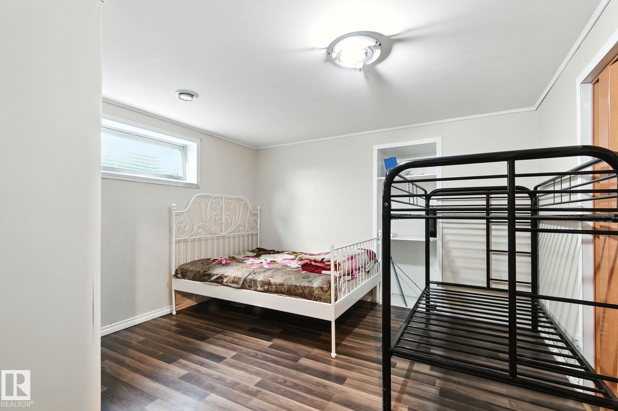 Bedroom with dark wood-type flooring and crown molding - 7836 7 Avenue, Edmonton, AB - Indoor Photo Showing Bedroom