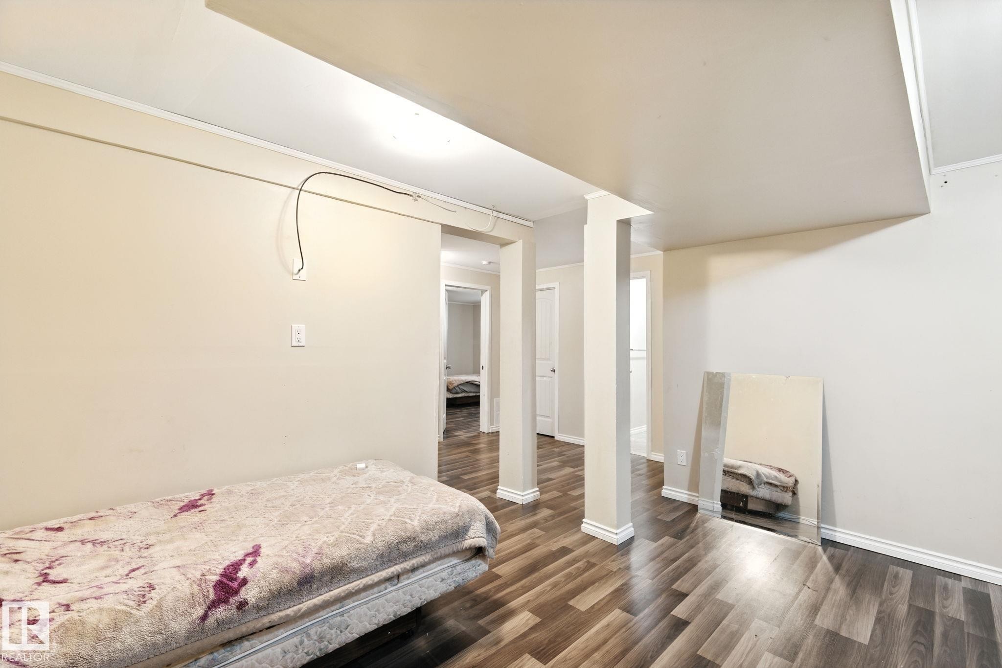 Bedroom with dark wood-type flooring and baseboards - 7836 7 Avenue, Edmonton, AB - Indoor Photo Showing Bedroom