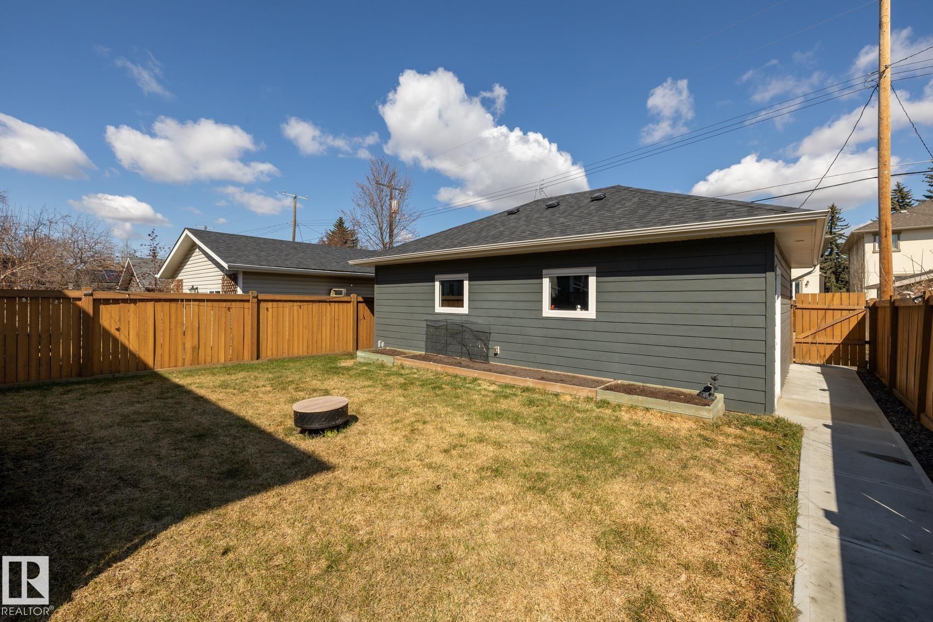 Rear view of house with a fenced backyard and roof with shingles - 10936 71 Avenue, Edmonton, AB - Outdoor