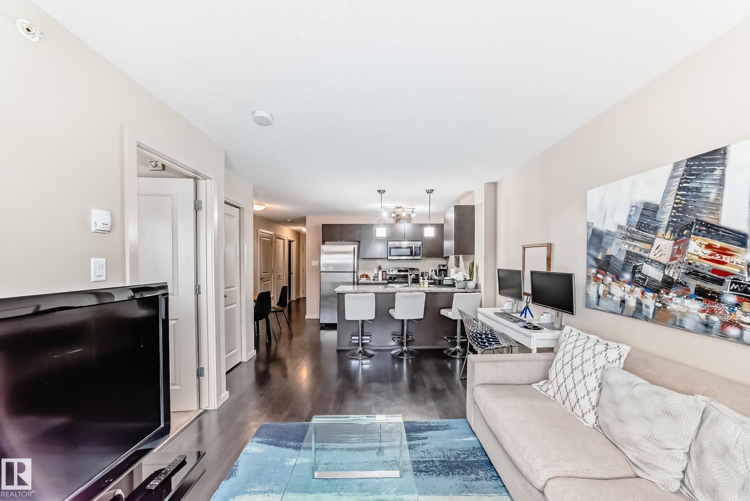 Living room with dark wood-type flooring - 403 340 Windermere Road, Edmonton, AB - Indoor Photo Showing Living Room