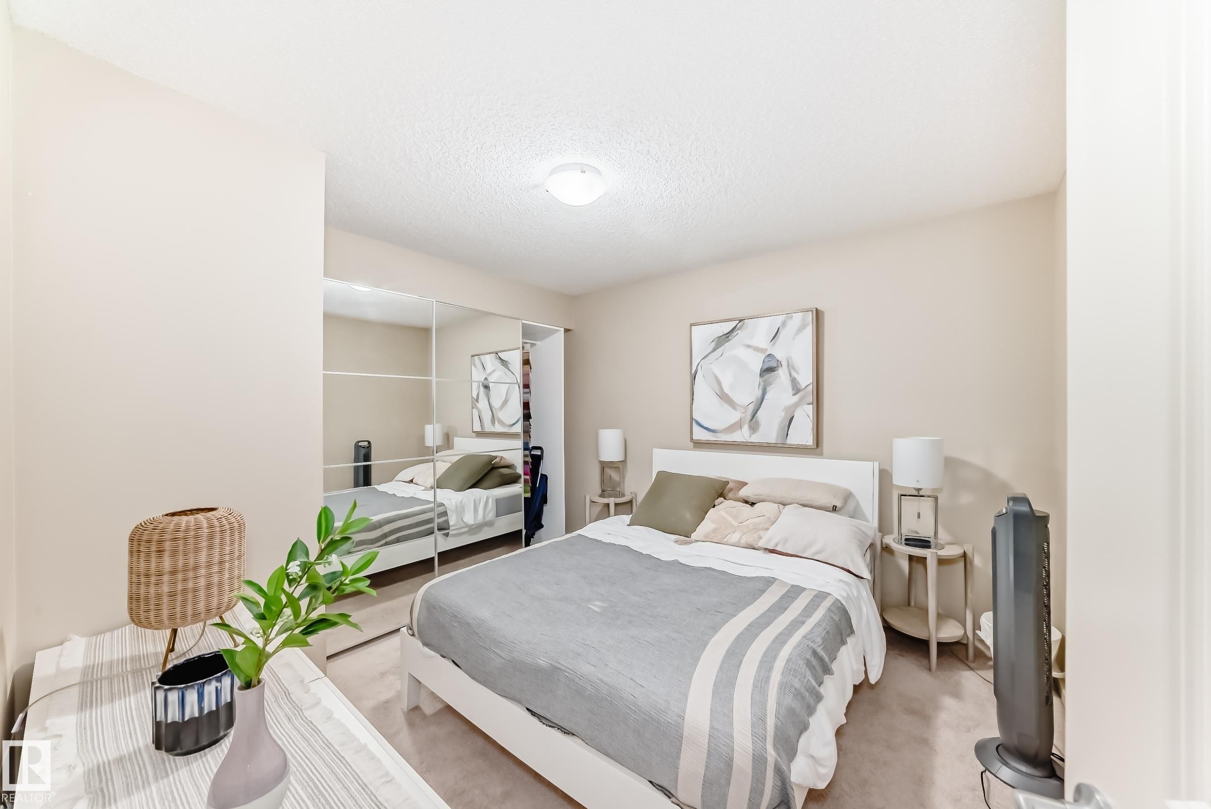 Bedroom with a closet, carpet flooring, and a textured ceiling - 403 340 Windermere Road, Edmonton, AB - Indoor Photo Showing Bedroom