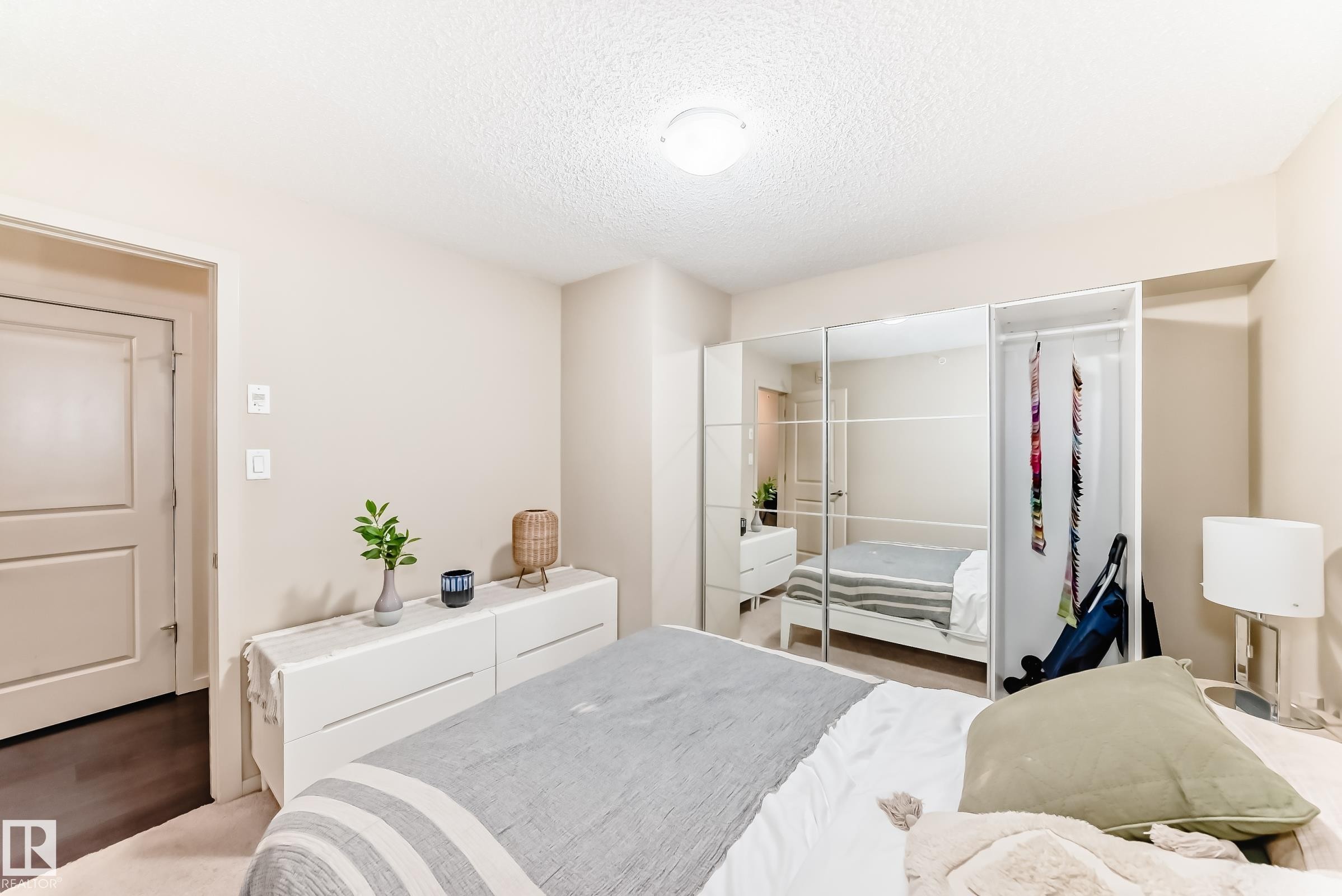 Bedroom with a textured ceiling and wood finished floors - 403 340 Windermere Road, Edmonton, AB - Indoor Photo Showing Bedroom
