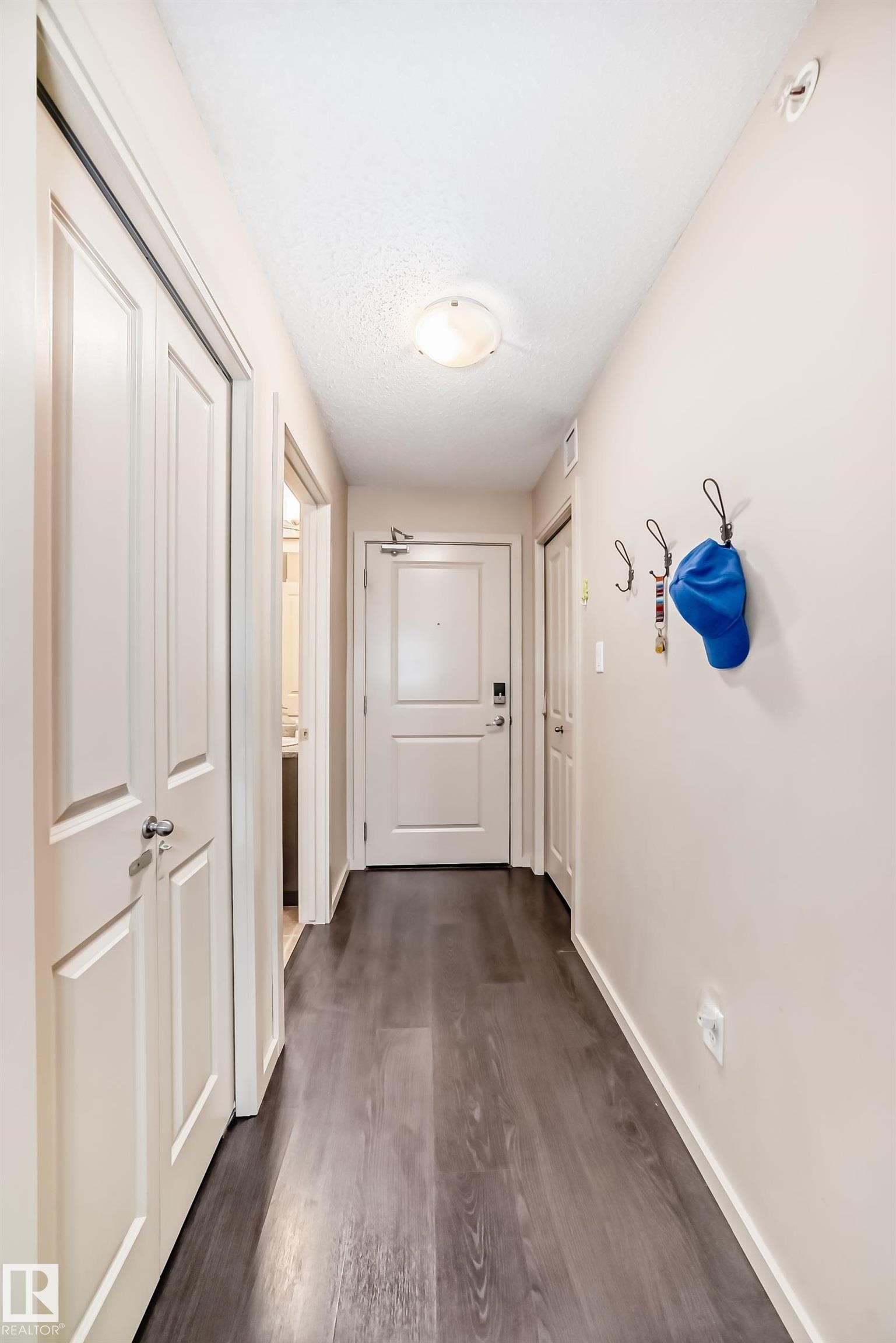 Corridor featuring dark wood-style flooring and a textured ceiling - 403 340 Windermere Road, Edmonton, AB - Indoor Photo Showing Other Room