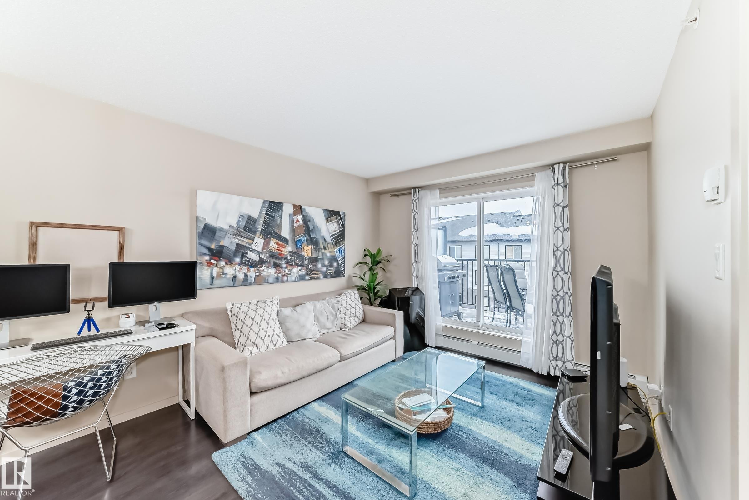 Living room with a desk and dark wood finished floors - 403 340 Windermere Road, Edmonton, AB - Indoor